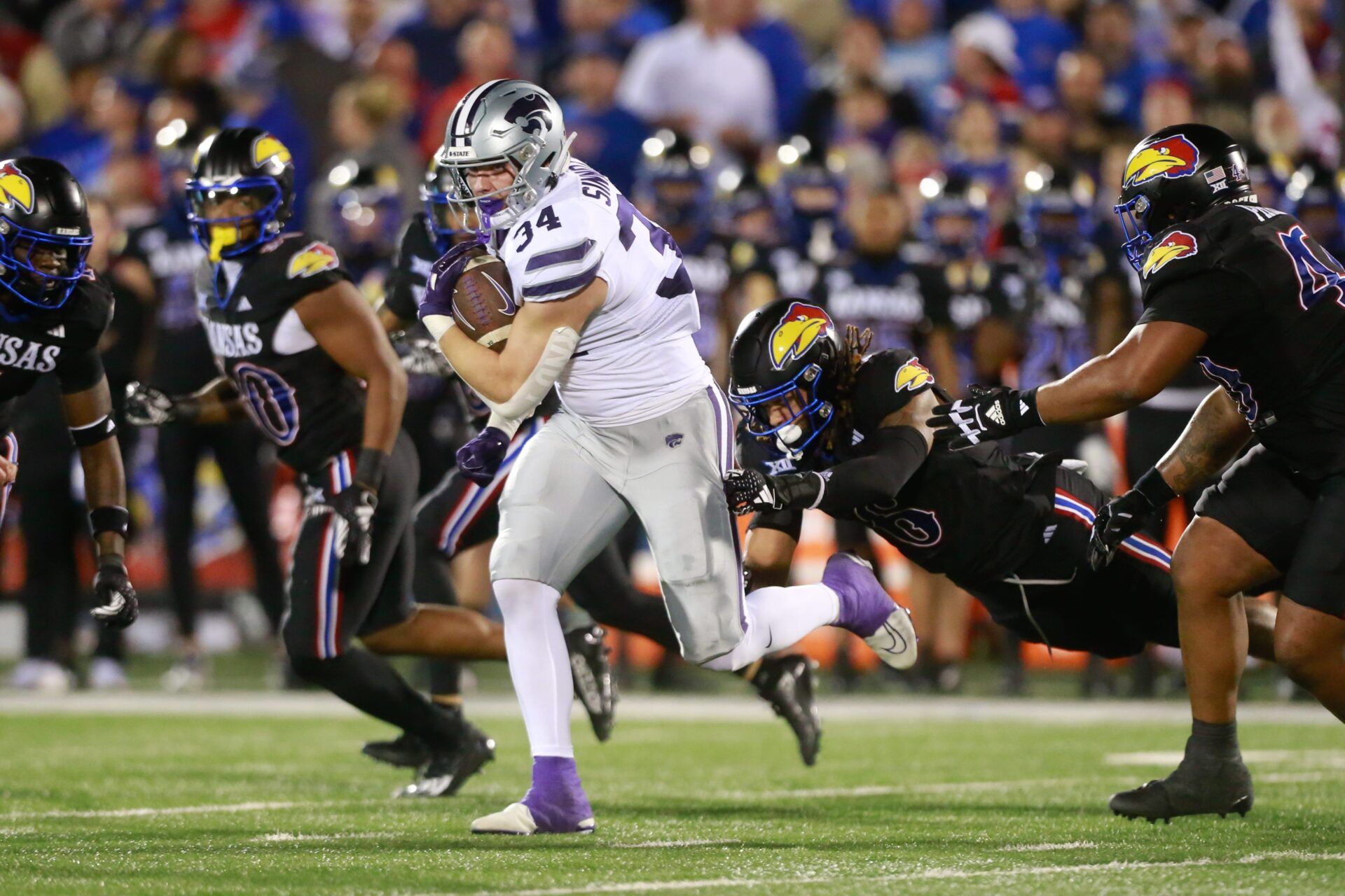 Kansas State junior tight end Ben Sinnott (34) drives through Kansas defenders during the first quarter of Saturday's Sunflower Showdown against Kansas inside David Booth Kansas Memorial Stadium.