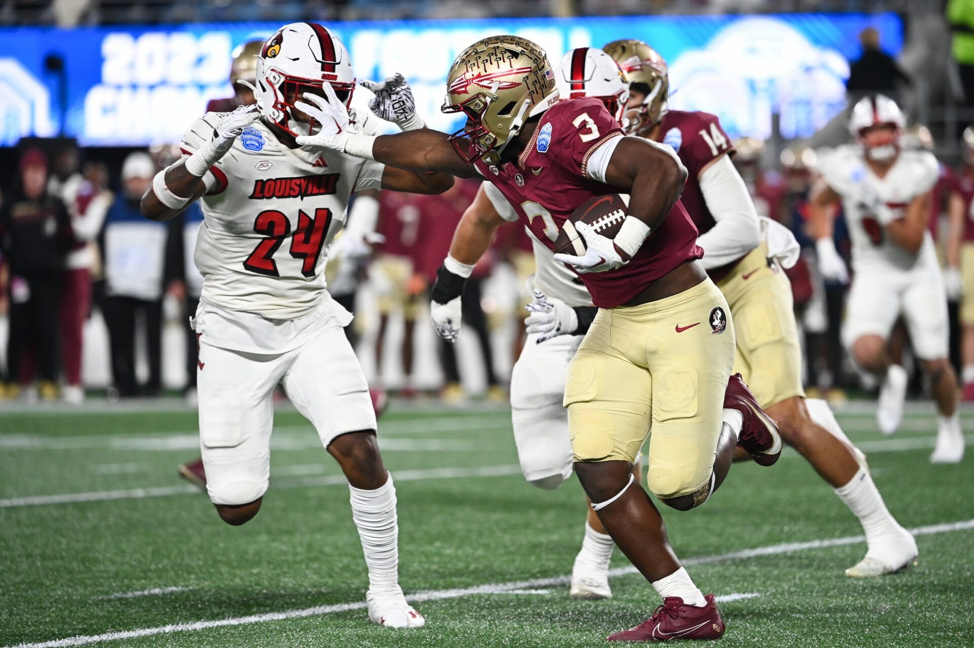 Florida State Seminoles running back Trey Benson (3) fends off Louisville Cardinals linebacker Jaylin Alderman (24) in the third quarter at Bank of America Stadium. Mandatory Credit: Bob Donnan-USA TODAY Sports