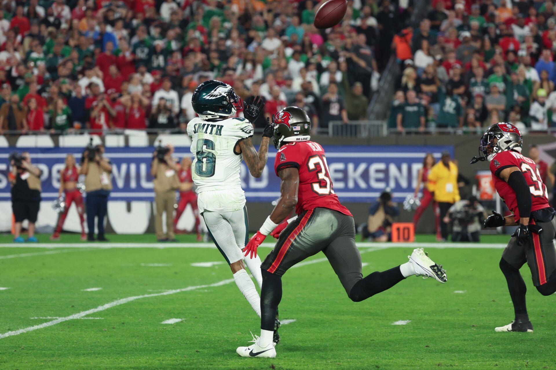 Philadelphia Eagles wide receiver DeVonta Smith (6) makes a catch as Tampa Bay Buccaneers cornerback Jamel Dean (35) pursues during the first half of a 2024 NFC wild card game at Raymond James Stadium.