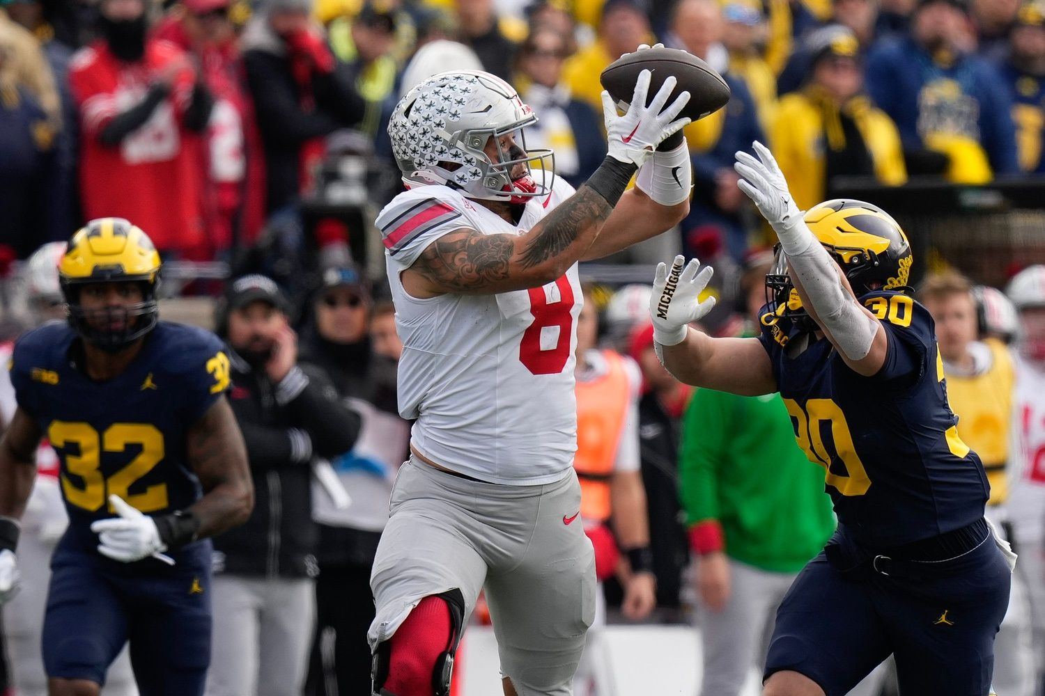 Ohio State Buckeyes tight end Cade Stover (8) catches a pass over Michigan Wolverines linebacker Jimmy Rolder (30) during the first half of the NCAA football game at Michigan Stadium.