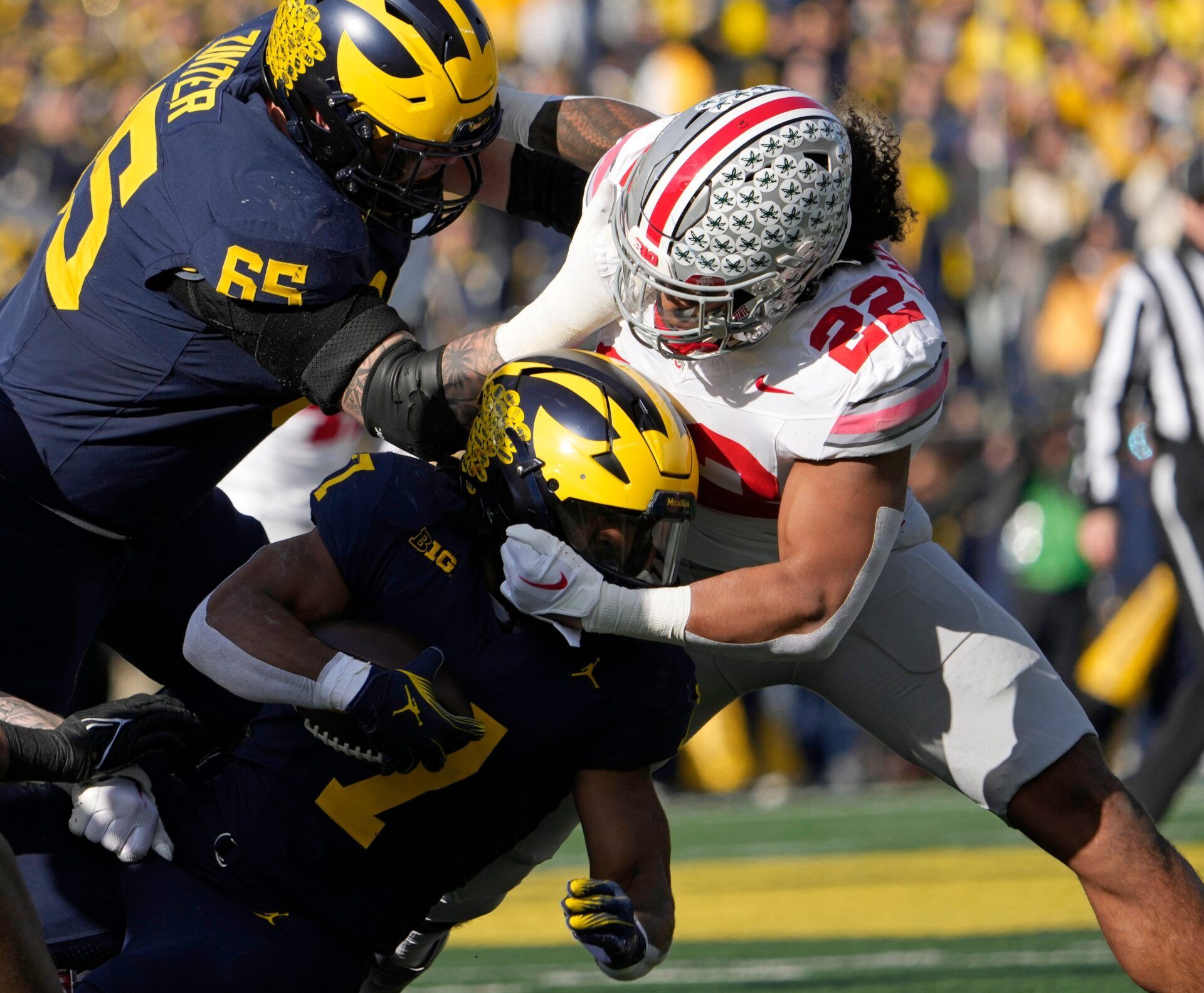 Michigan Wolverines running back Donovan Edwards (7) is tackled by Ohio State Buckeyes linebacker Steele Chambers (22) during the first half of Saturday's NCAA Division I football game at Michigan Stadium.