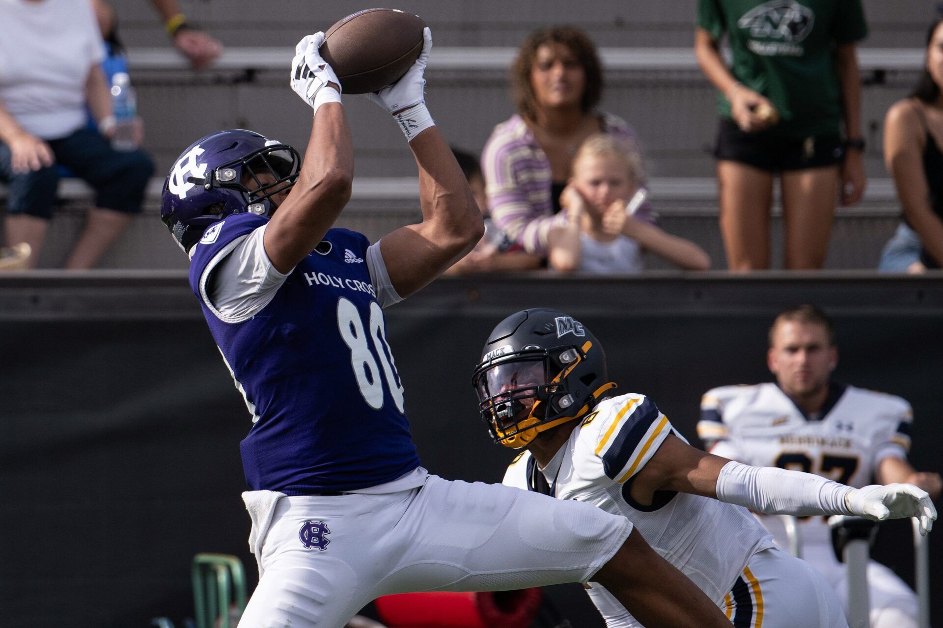 Holy Cross's Jalen Coker hauls in a pass for a first down over Merrimack's Darion McKenzie in the third quarter Saturday at Fitton Field.