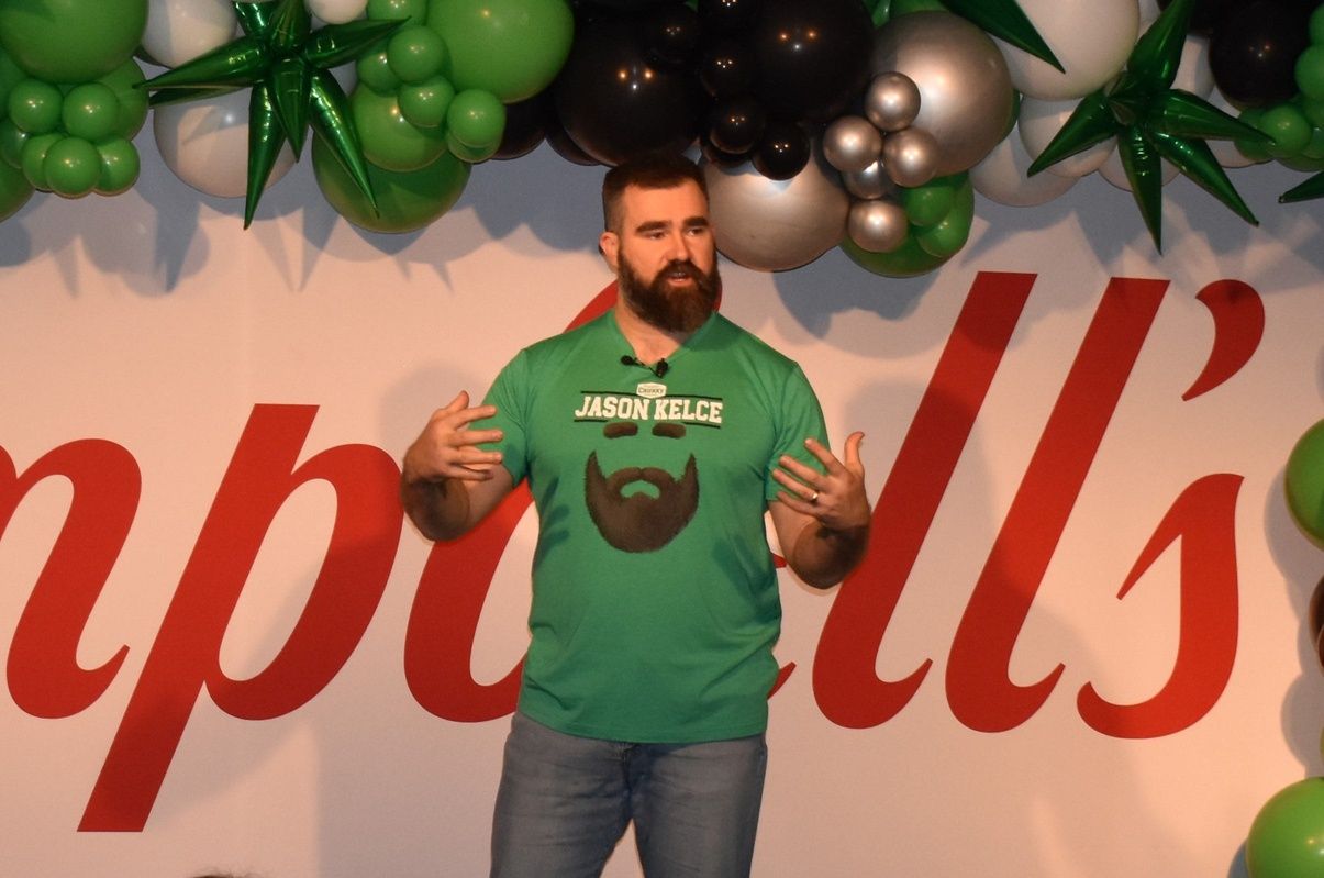 Retired Eagle Jason Kelce, wearing a shirt that promotes his Legend Edition Chunky soup can, addresses some 600 Campbell Soup Co. workers during a visit to the firm's Camden headquarters.