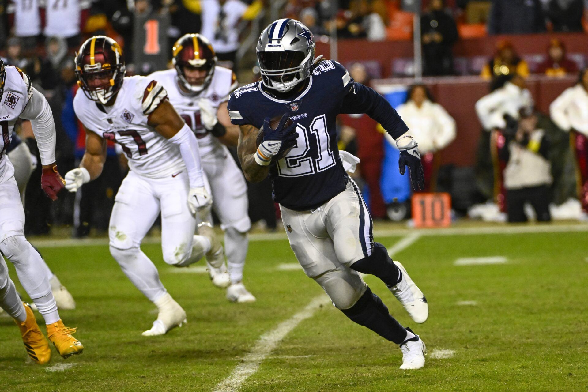 Dallas Cowboys running back Ezekiel Elliott (21) carries the ball against the Washington Commanders during the second half at FedExField. Mandatory Credit: Brad Mills-USA TODAY Sports