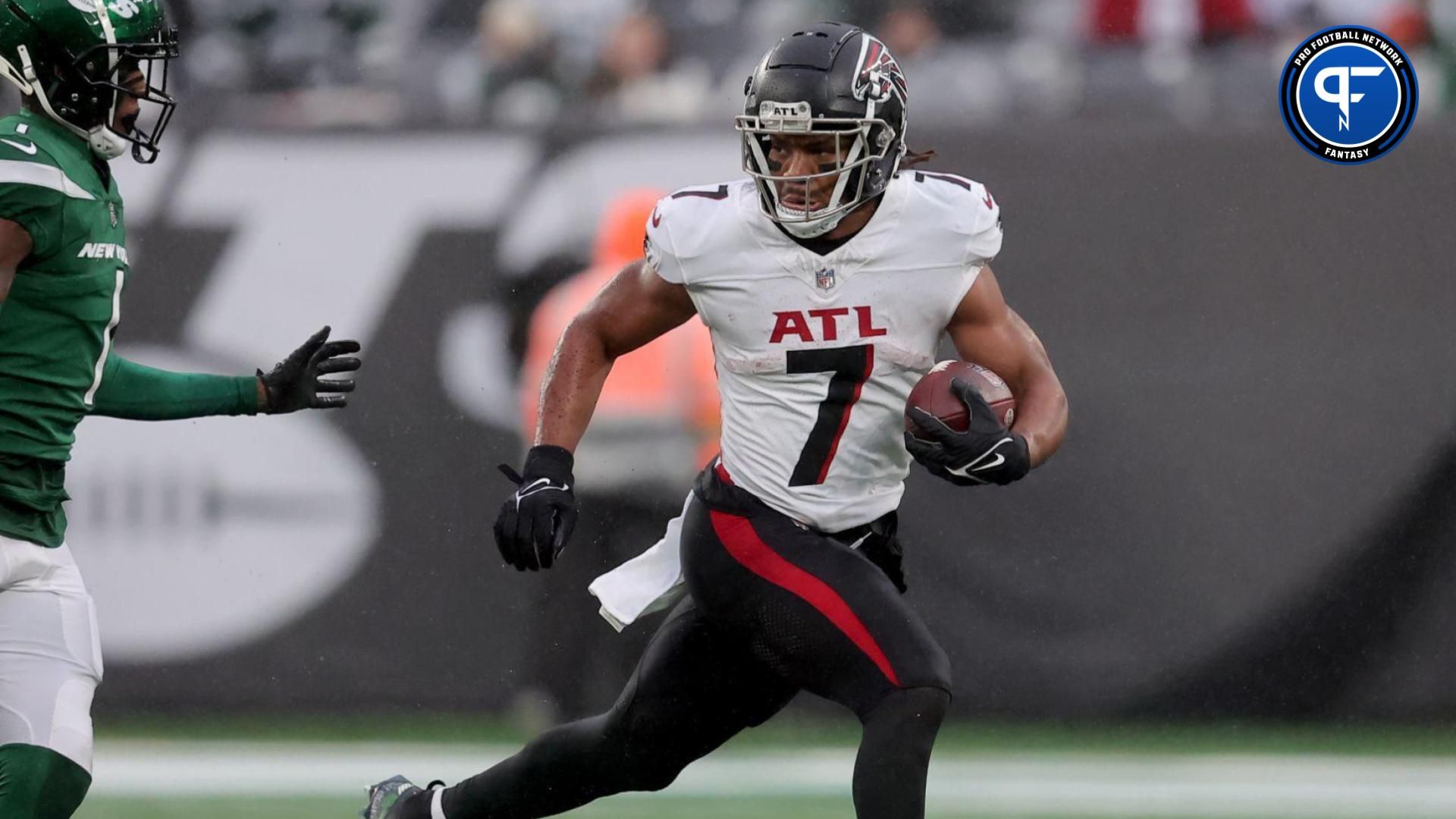 Atlanta Falcons running back Bijan Robinson (7) runs with the ball against New York Jets cornerback D.J. Reed (4) and cornerback Sauce Gardner (1) during the third quarter at MetLife Stadium.