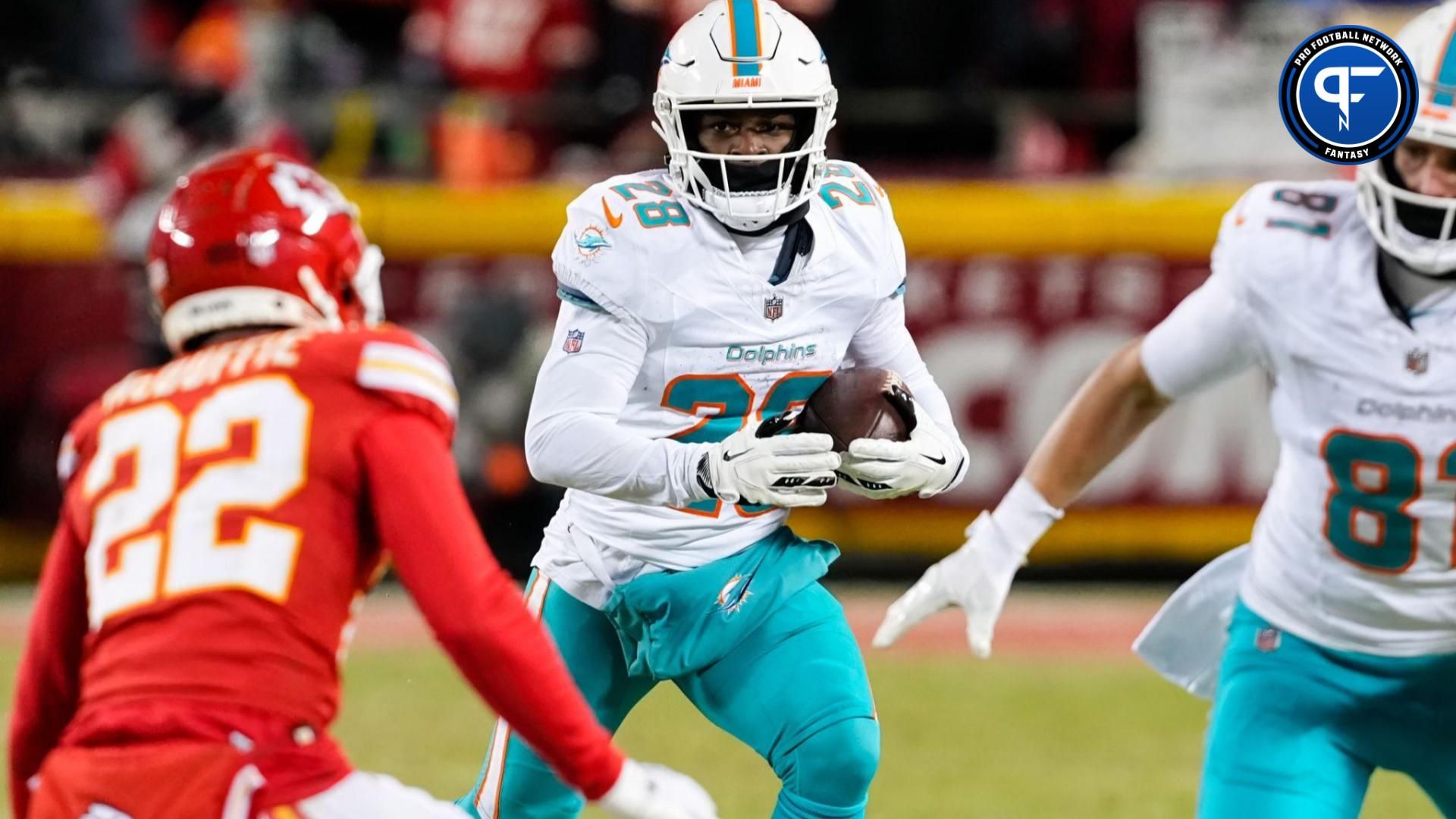 Miami Dolphins running back De'Von Achane (28) runs the ball against Kansas City Chiefs cornerback Trent McDuffie (22) during the second half of a 2024 AFC wild card game at GEHA Field at Arrowhead Stadium.