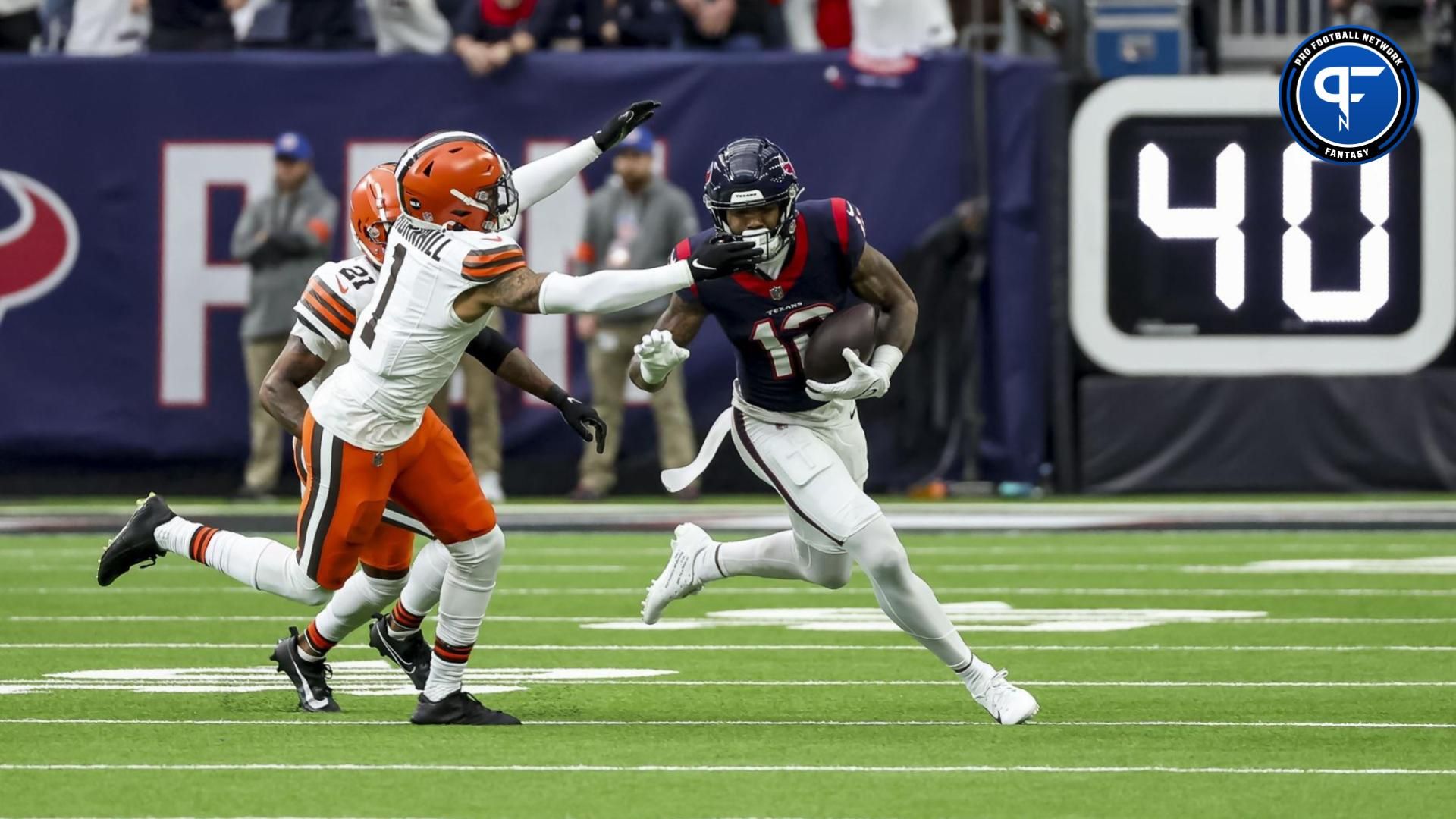 Houston Texans wide receiver Nico Collins (12) dodges Cleveland Browns safety Juan Thornhill (1) during the first quarter in a 2024 AFC wild card game at NRG Stadium.