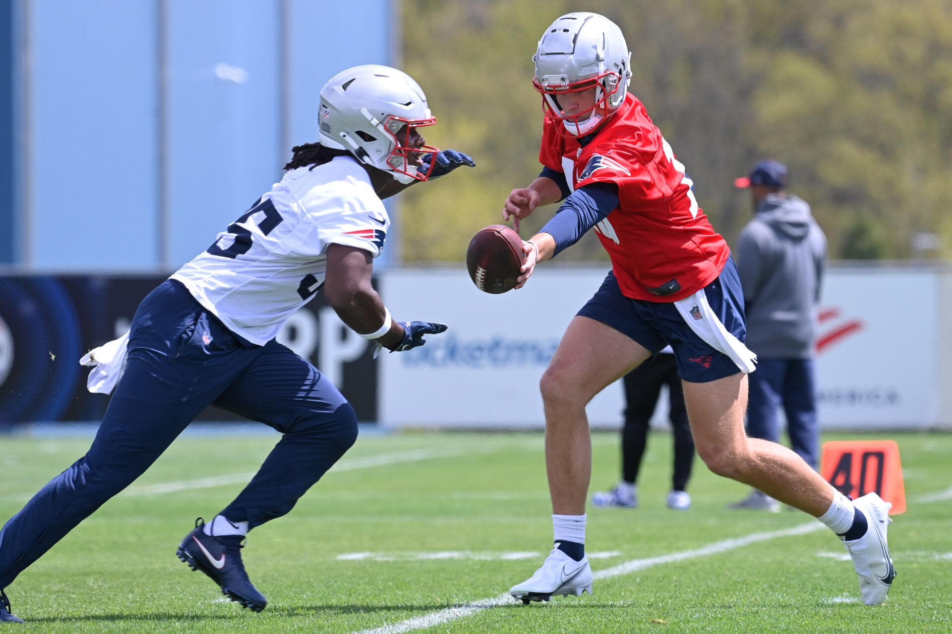 New England Patriots quarterback Drake Maye (10) hands the ball to running back Deshaun Fenwick (35) at the New England Patriots rookie camp at Gillette Stadium.