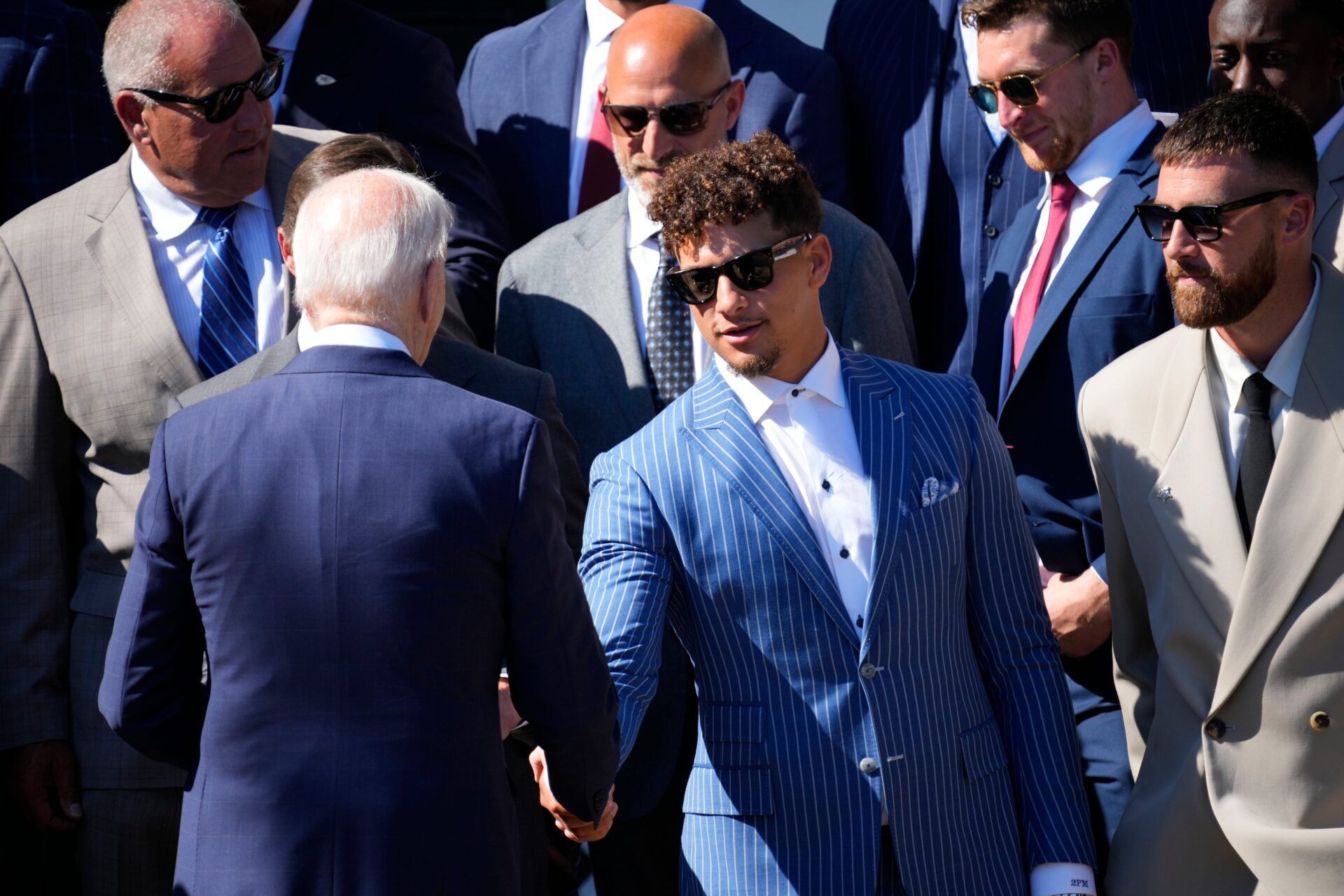 President Joe Biden shakes hands with Kansas City Chiefs quarterback Patrick Mahomes as he welcomes the team to the White House to celebrate their championship season and victory in Super Bowl LVIII on Friday, May 31, 2024. At right is tight end Travis Kelce.