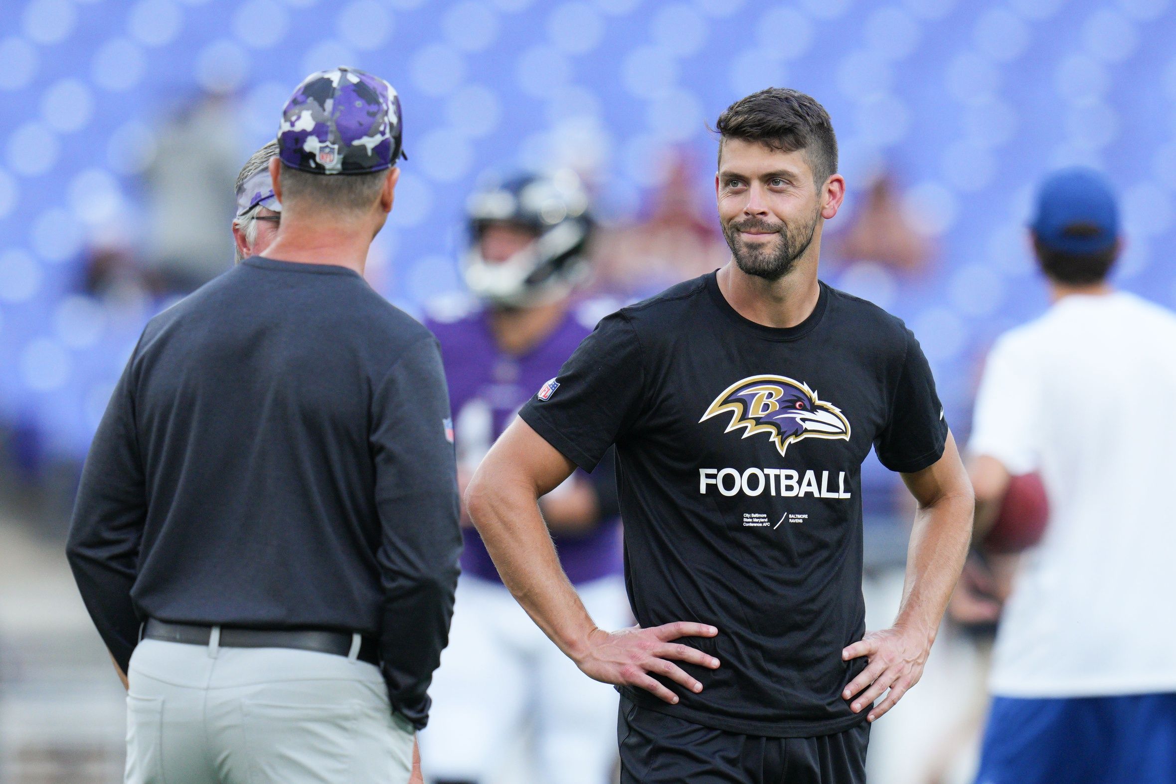 Baltimore Ravens place kicker Justin Tucker (9) speaks with head coach John Harbaugh on the field before the game against the Washington Commanders at M&T Bank Stadium.