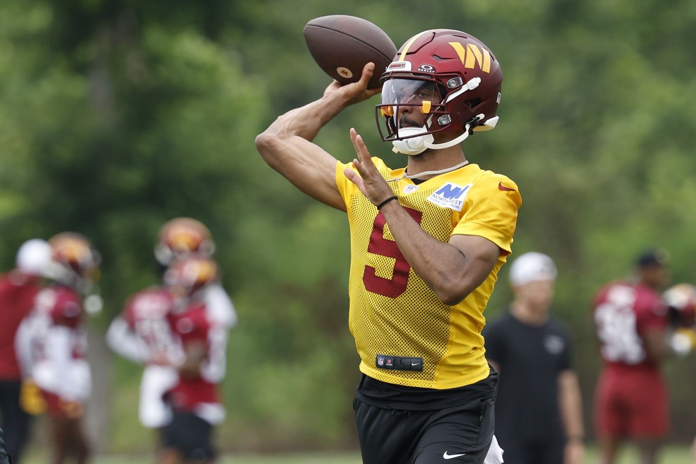 Washington Commanders quarterback Jayden Daniels (5) passes a ball during an OTA workout at Commanders Park. Mandatory Credit: Geoff Burke-USA TODAY Sports