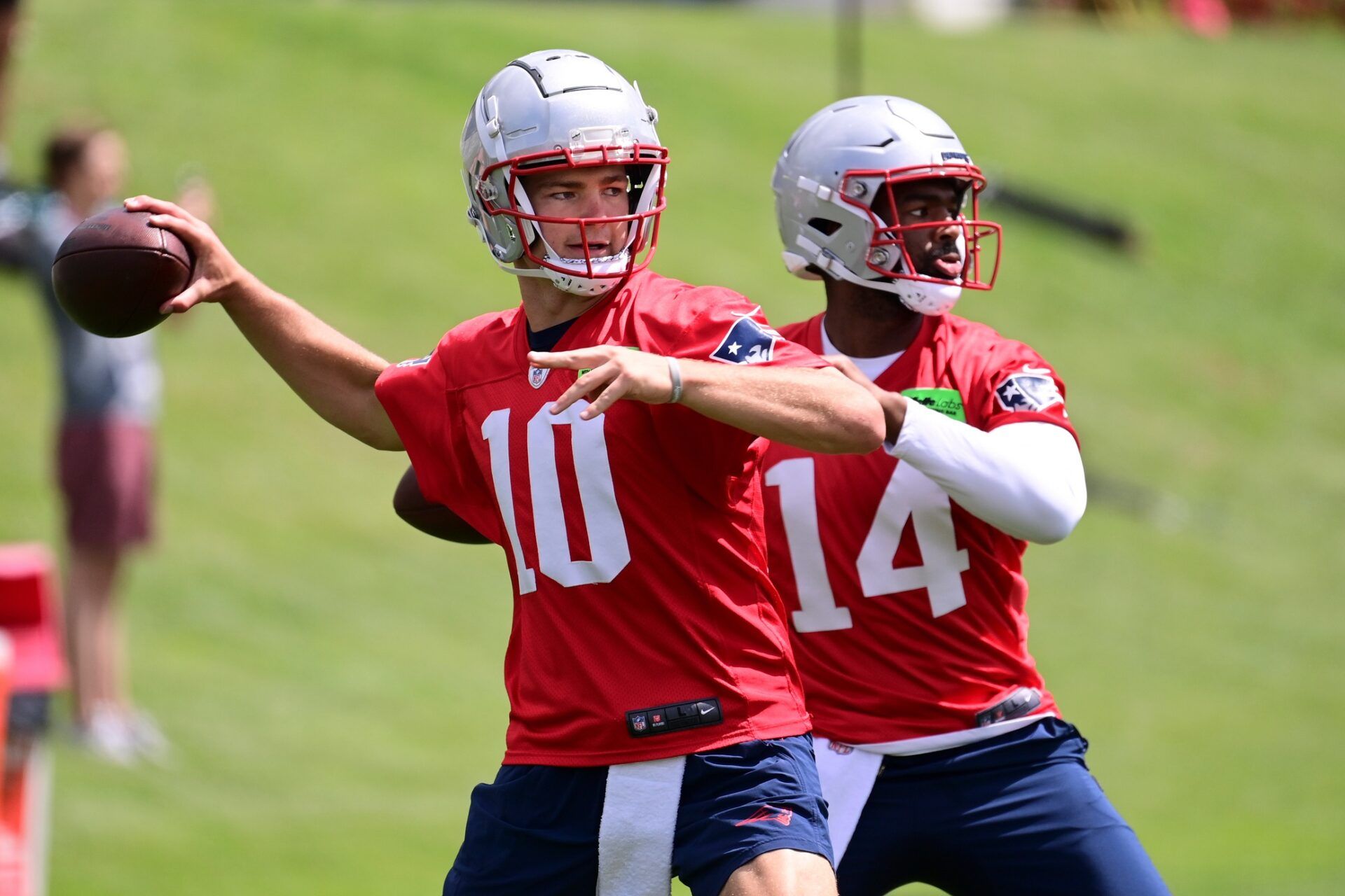 New England Patriots quarterbacks Drake Maye (10) and Jacoby Brissett (14) throw passes during mandatory minicamp.