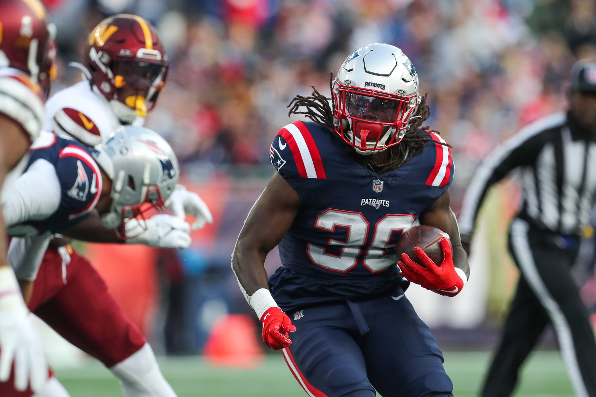 New England Patriots running back Rhamondre Stevenson (38) runs the ball during the second half against the Washington Commanders at Gillette Stadium. Mandatory Credit: Paul Rutherford-USA TODAY Sports