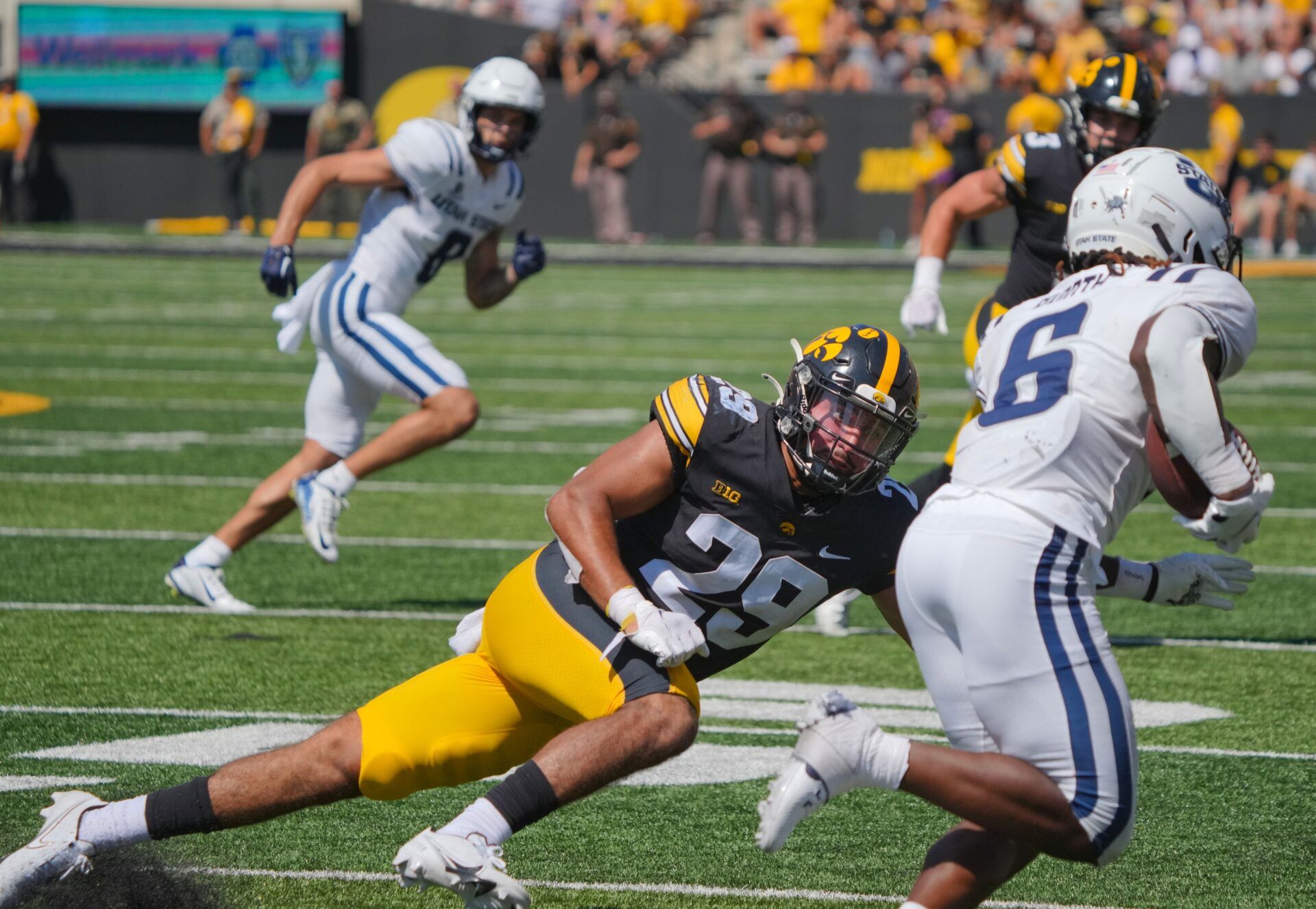 Iowa Hawkeyes safety Sebastian Castro (28) tries to tackle a Utah State player.