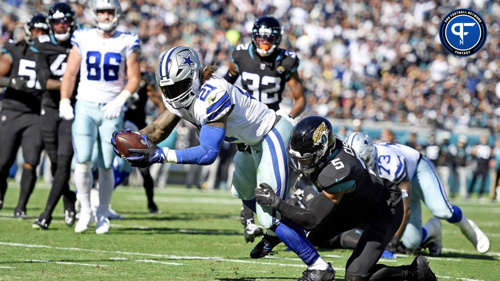 Dallas Cowboys running back Ezekiel Elliott (21) rushes for a touchdown through the defense of Jacksonville Jaguars safety Andre Cisco (5) during the first quarter at TIAA Bank Field.