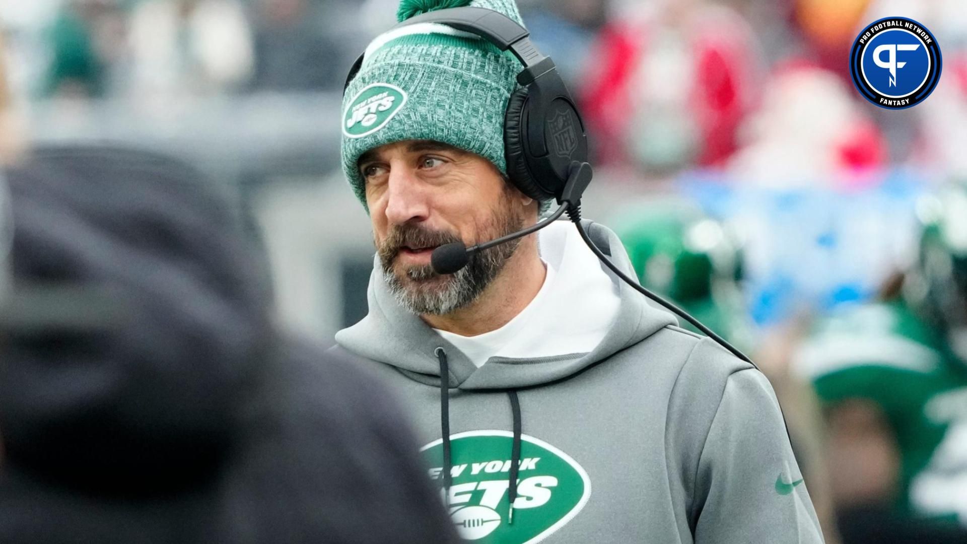 New York Jets QB Aaron Rodgers smiles while on the sidelines.