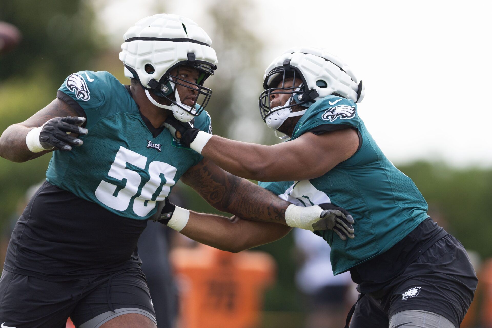 Philadelphia Eagles guard Tyler Steen (R) and offensive tackle Fred Johnson (50) run drills during practice at Novacare Complex.