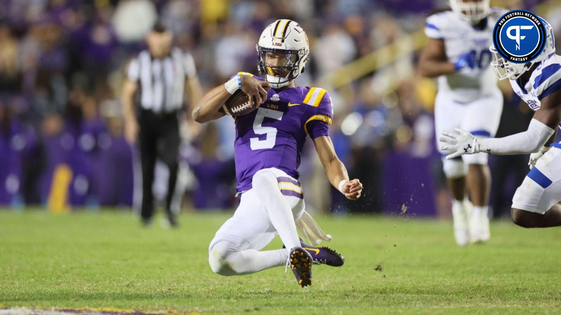 LSU Tigers quarterback Jayden Daniels (5) slides after a run as Georgia State Panthers safety Jeremiah Johnson (6) looks on in the third quarter at Tiger Stadium.