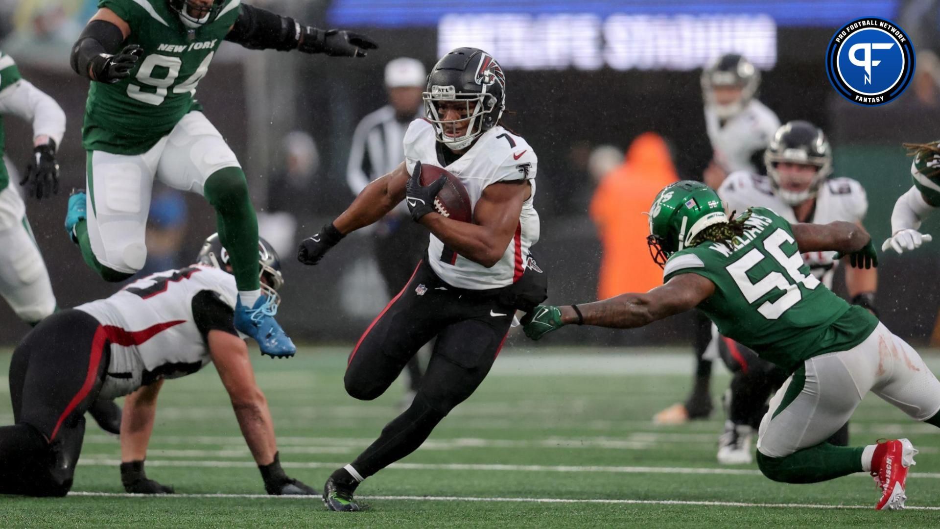 Atlanta Falcons running back Bijan Robinson (7) runs with the ball against New York Jets defensive end Solomon Thomas (94) and linebacker Quincy Williams (56) during the third quarter at MetLife Stadium.