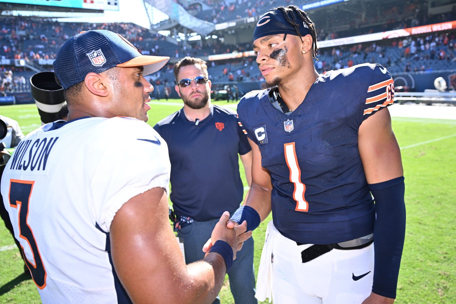 Chicago Bears quarterback Justin Fields (1), right, meets with Denver Broncos quarterback Russell Wilson (3) at midfield after their game at Soldier Field. The two will now compete as teammates during NFL Training Camp. Mandatory Credit: Jamie Sabau-USA TODAY Sports