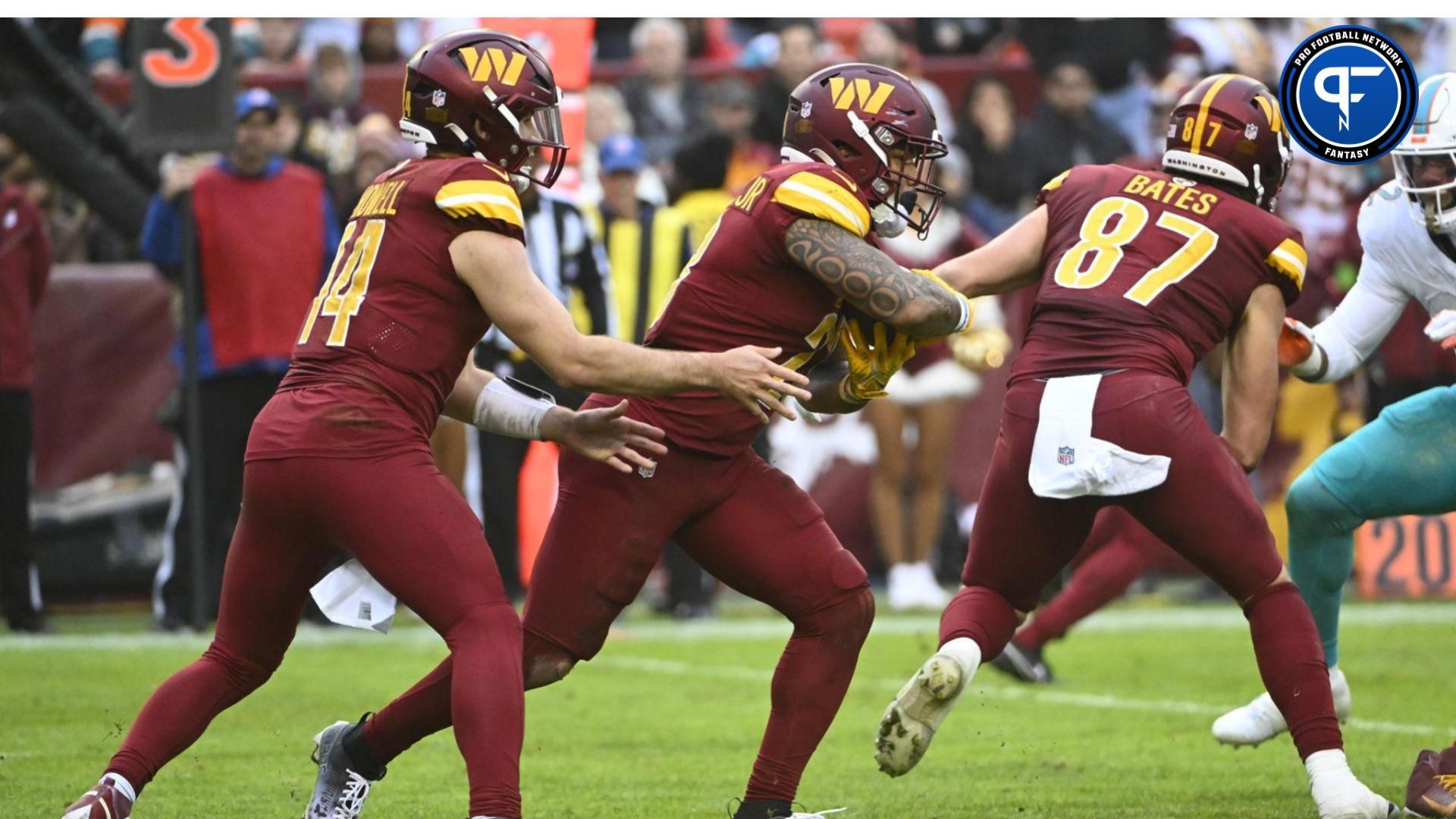 Washington Commanders running back Brian Robinson Jr. (8) receives the handoff from quarterback Sam Howell (14) against the Miami Dolphins during the second half at FedExField