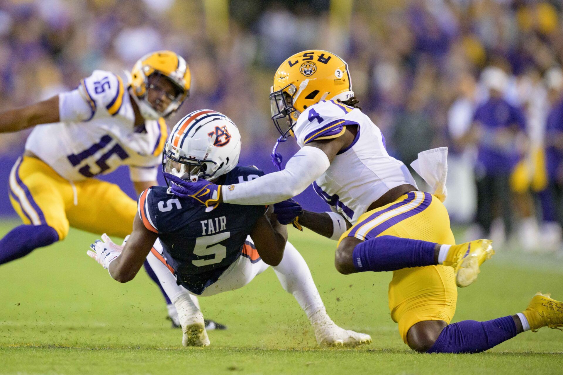 LSU Tigers linebacker Harold Perkins Jr. (4) gets his fingers caught in the helmet of Auburn Tigers wide receiver Jay Fair (5) but there was no flag during the first quarter at Tiger Stadium. Perkins lands in Los Angeles in our latest Chargers mock draft. Mandatory Credit: Matthew Hinton-USA TODAY Sports