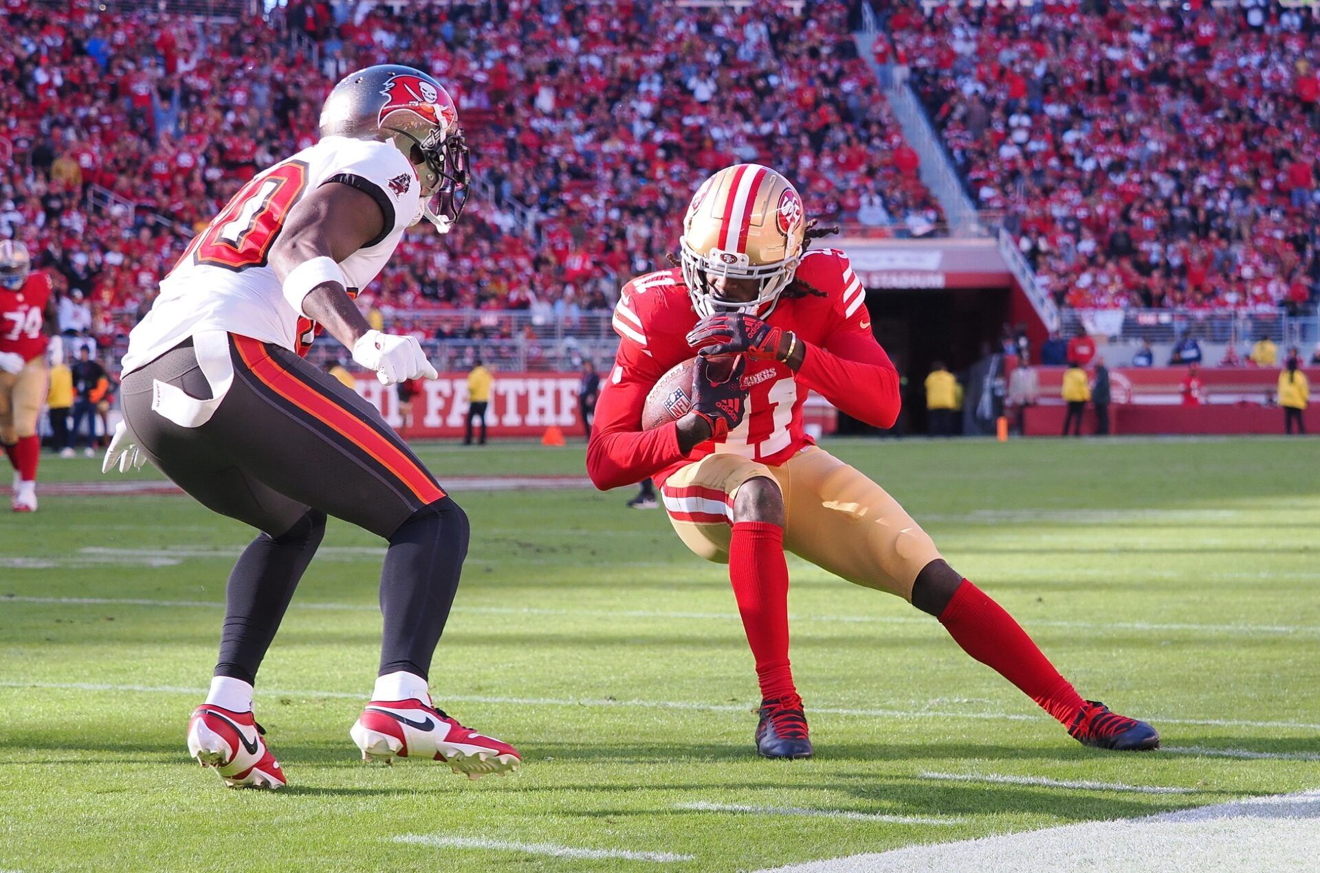 San Francisco 49ers wide receiver Brandon Aiyuk (11) leans into the play against Tampa Bay Buccaneers defensive back Dee Delaney (30) during the second quarter at Levi's Stadium.