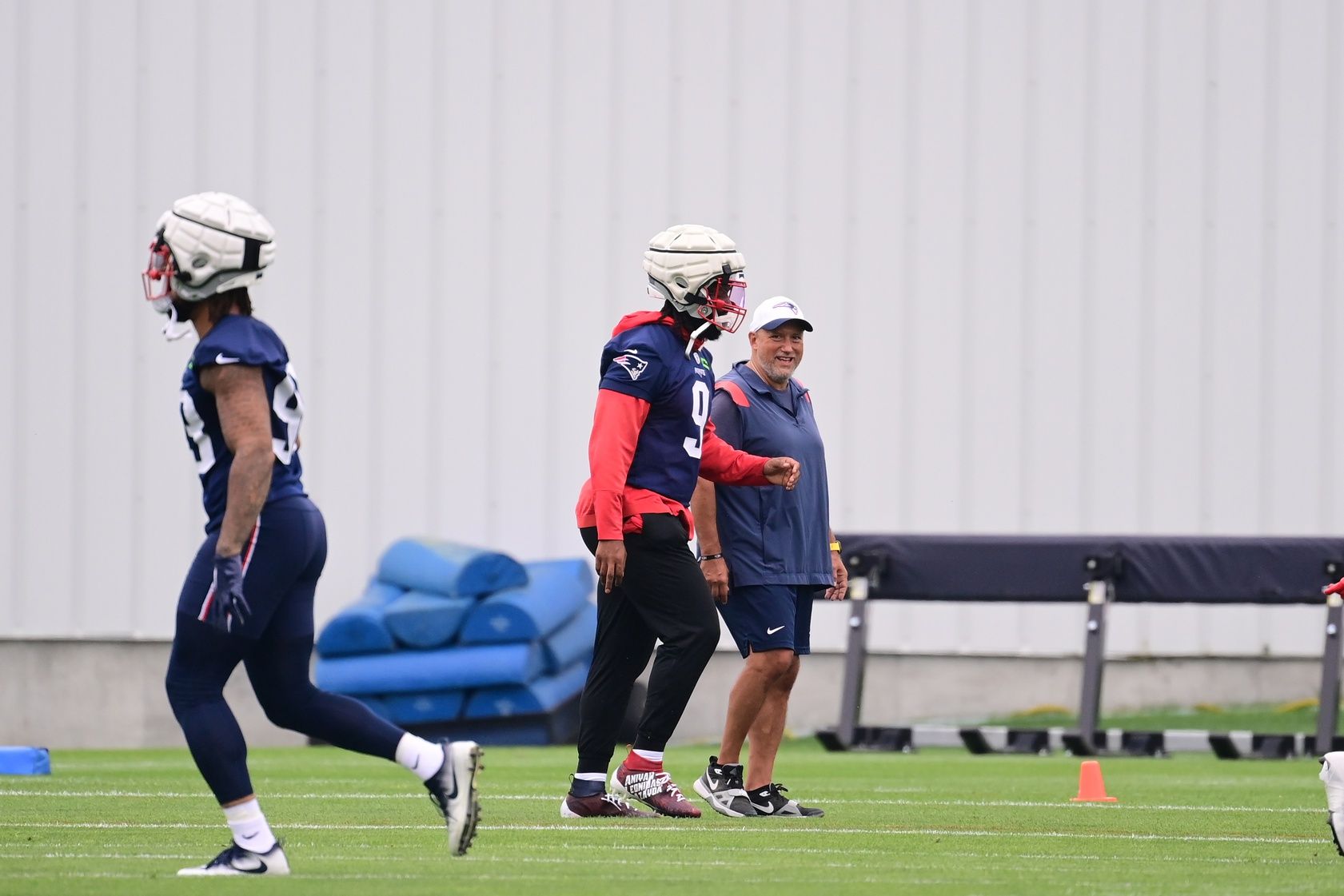 Jul 24, 2024; Foxborough, MA, USA; New England Patriots linebacker Matthew Judon (9) talks to director of skill development Joe Kim during training camp at Gillette Stadium. Mandatory Credit: Eric Canha-USA TODAY Sports