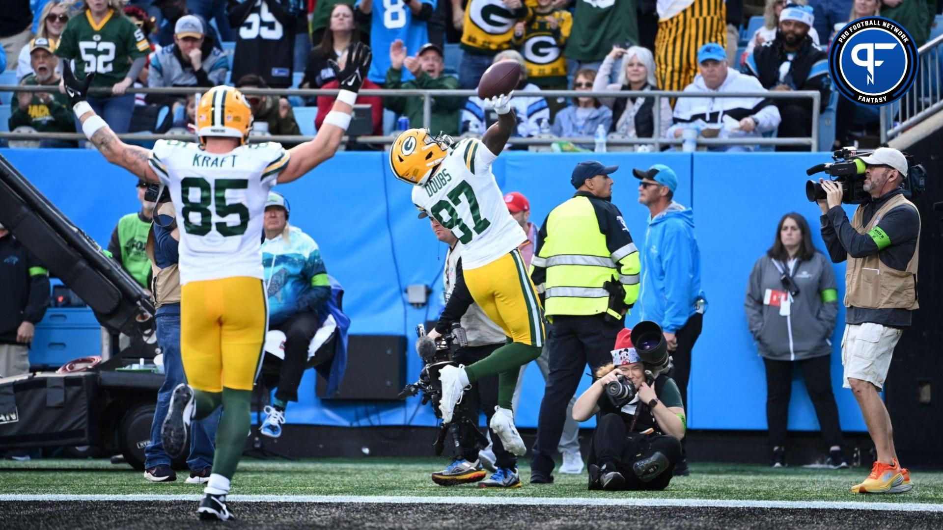 Green Bay Packers wide receiver Romeo Doubs (87) throws the ball to Green Bay Packers fans in the stands after scoring a touchdown as tight end Tucker Kraft (85) celebrates in the fourth quarter at Bank of America Stadium.