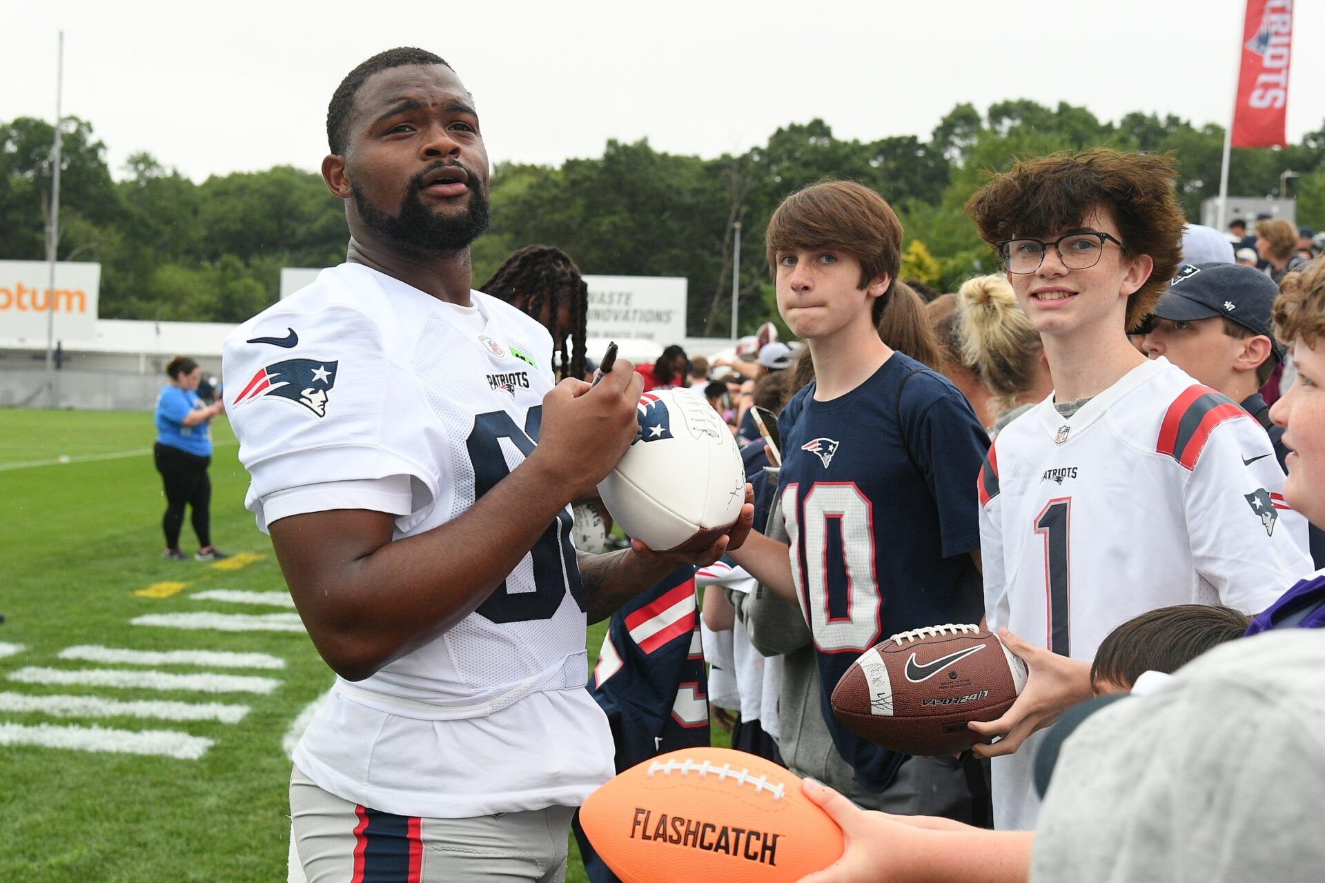 New England Patriots wide receiver Kayshon Boutte (80) signs an autograph for a fan during training camp at Gillette Stadium.