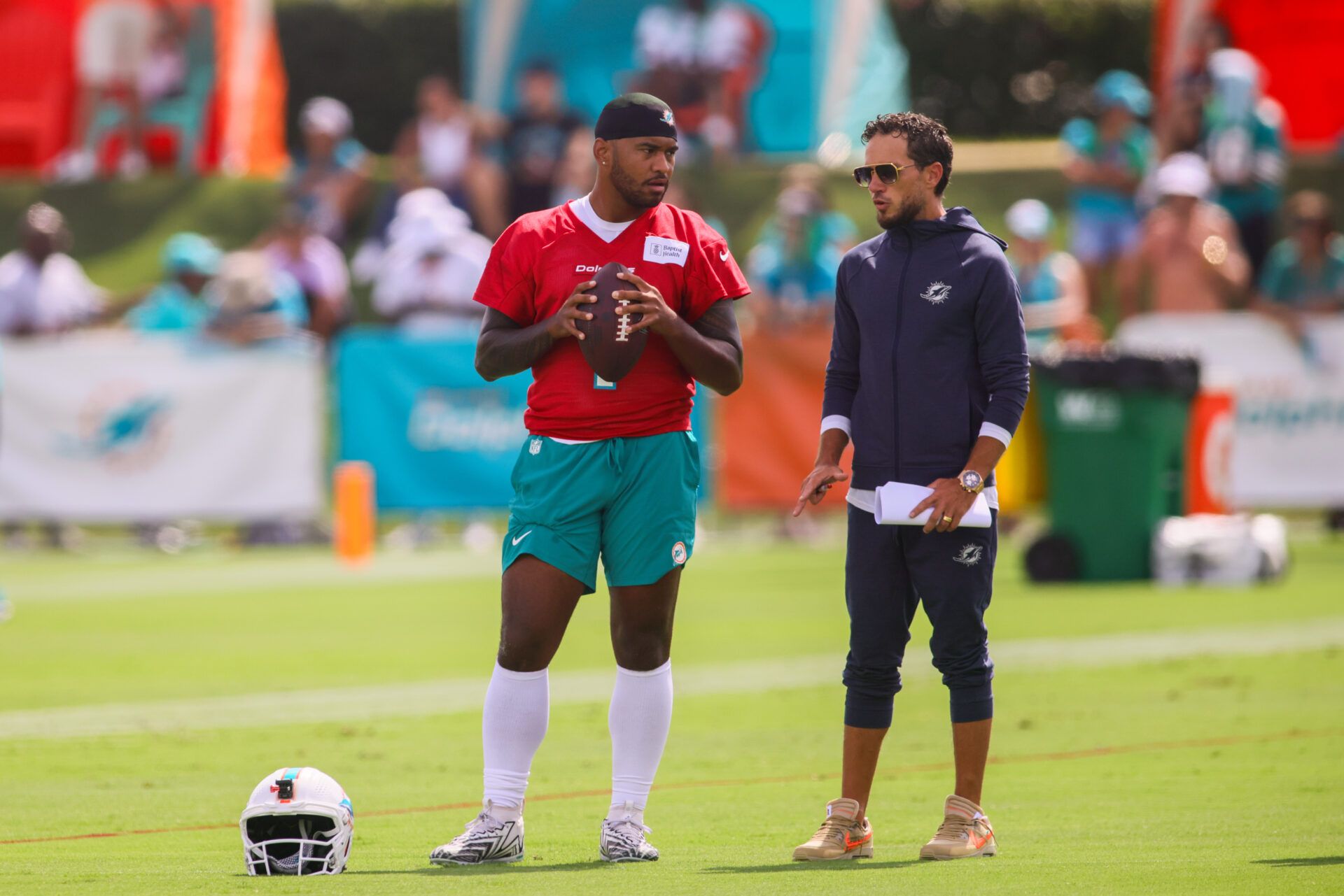 Jul 28, 2024; Miami Gardens, FL, USA; Miami Dolphins quarterback Tua Tagovailoa (1) talks to head coach Mike McDaniel during training camp at Baptist Health Training Complex. Mandatory Credit: Sam Navarro-USA TODAY Sports