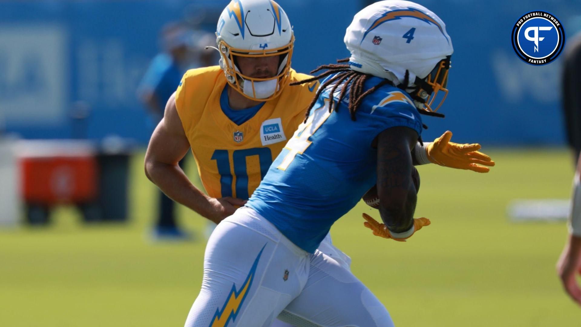 Los Angeles Chargers quarterback Justin Herbert (10) hands a ball off to running back Gus Edwards (4) during the first day of training camp at The Bolt.