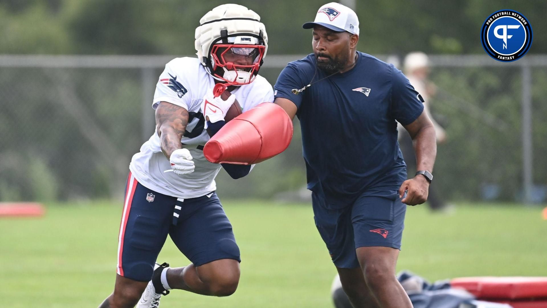 Aug 03, 2024; Foxborough, MA, USA; New England Patriots head coach Jerod Mayo works with running back Antonio Gibson (21) during training camp at Gillette Stadium. Mandatory Credit: Eric Canha-USA TODAY Sports