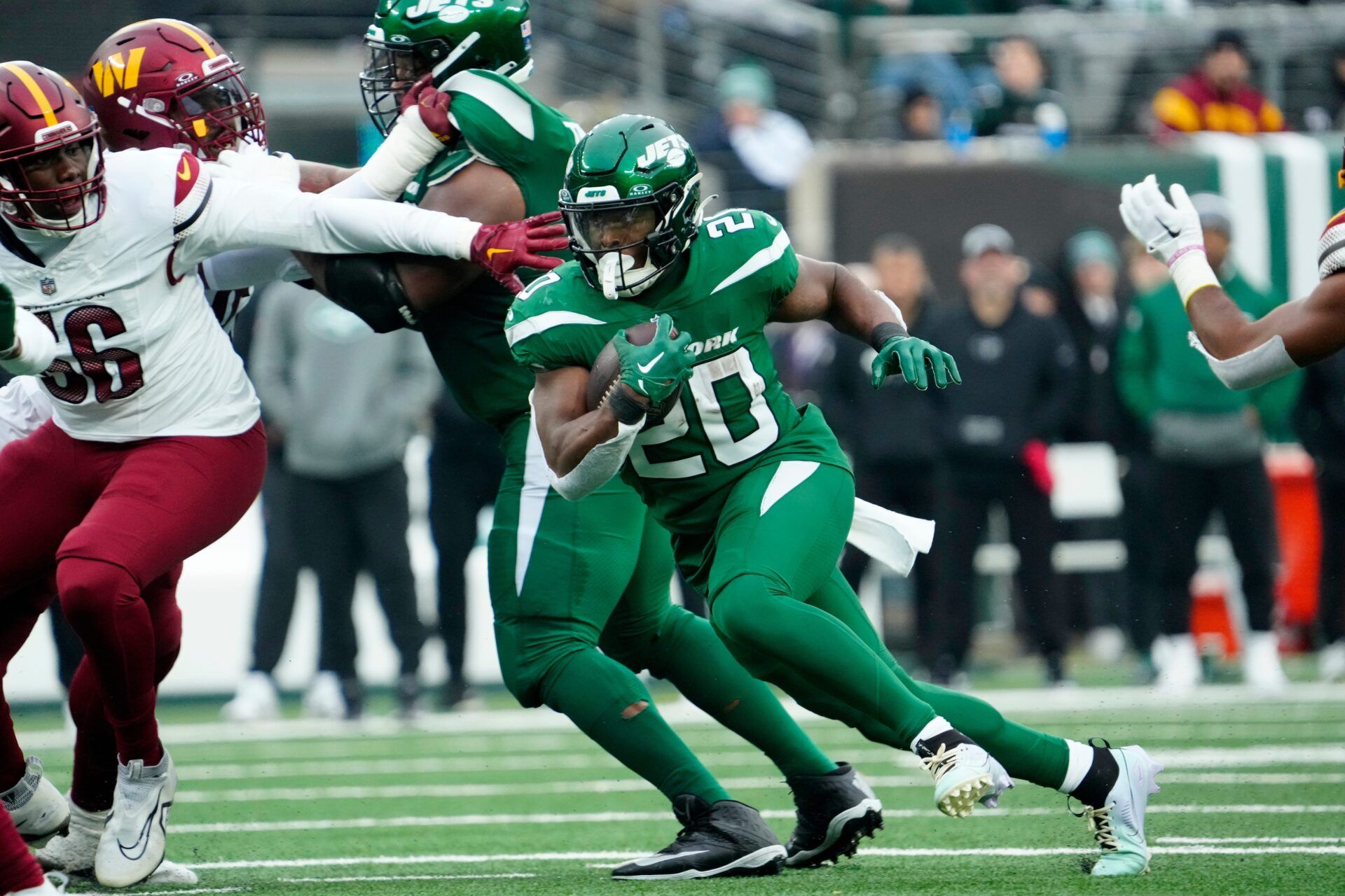 New York Jets running back Israel Abanikanda (25) runs through some Washington Commanders defense, at MetLife Stadium, Sunday December 24, 2023.