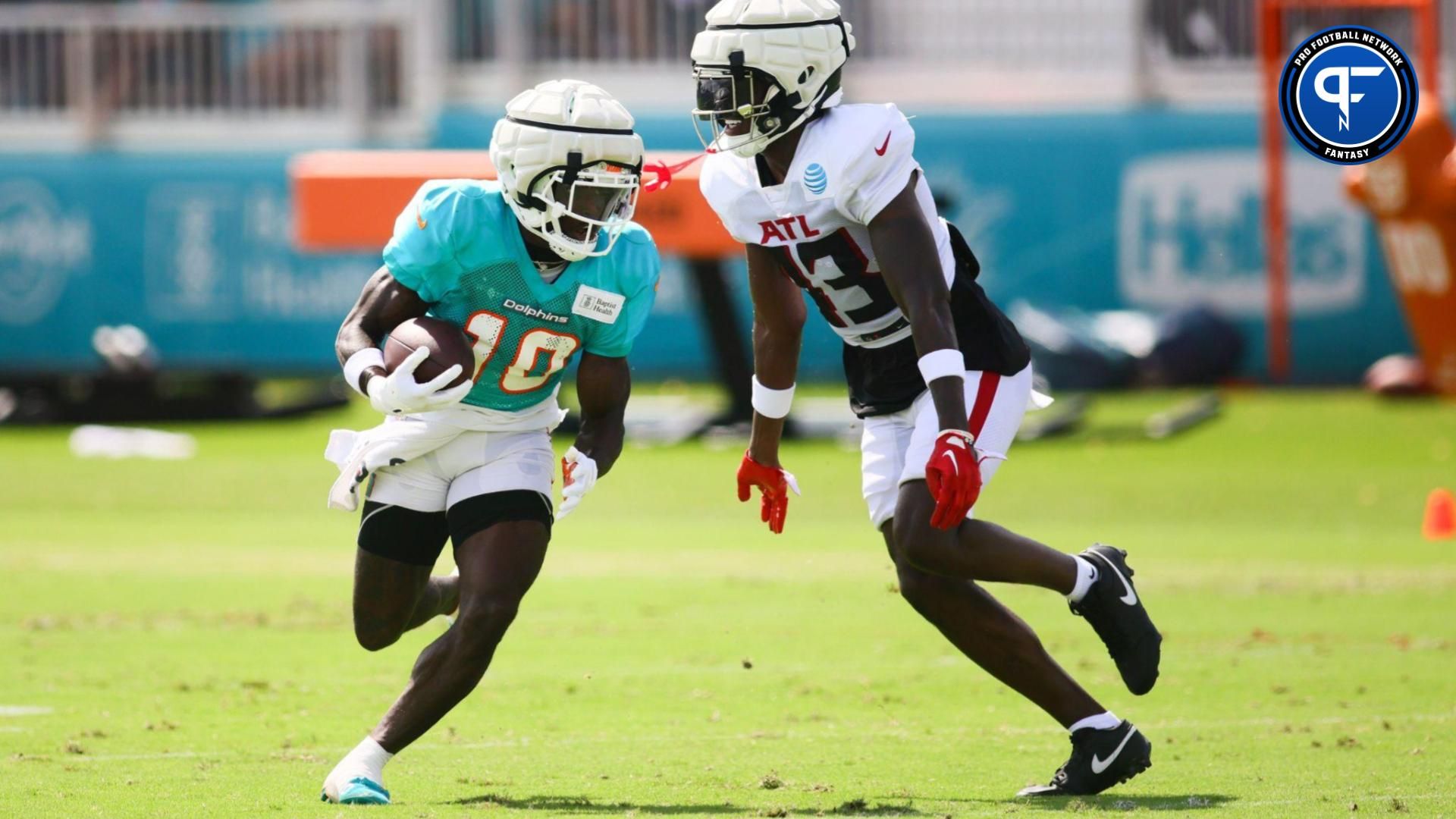 Miami Dolphins wide receiver Tyreek Hill (10) runs with the football against Atlanta Falcons cornerback Anthony Johnson (43) during a joint practice at Baptist Health Training Complex.