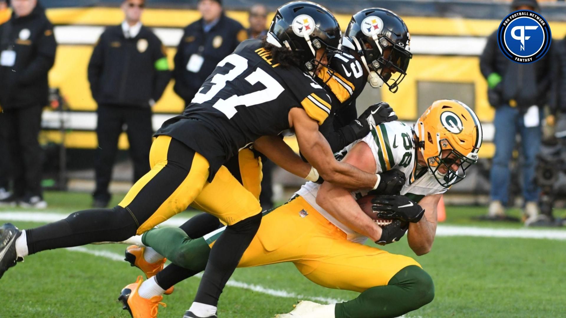 Green Bay Packers tight ens Luke Musgrave (88) is tackled by Pittsburgh Steelers cornerback Levi Wallace (29) and safety Elijah Riley (37) after a 36 yard pass during the third quarter at Acrisure Stadium.