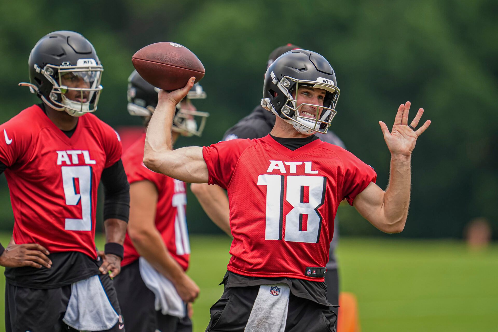 Atlanta Falcons quarterback Kirk Cousins (18) throws while quarterback Michael Penix Jr (9) watches on the field during Falcons OTA at the Falcons Training facility.