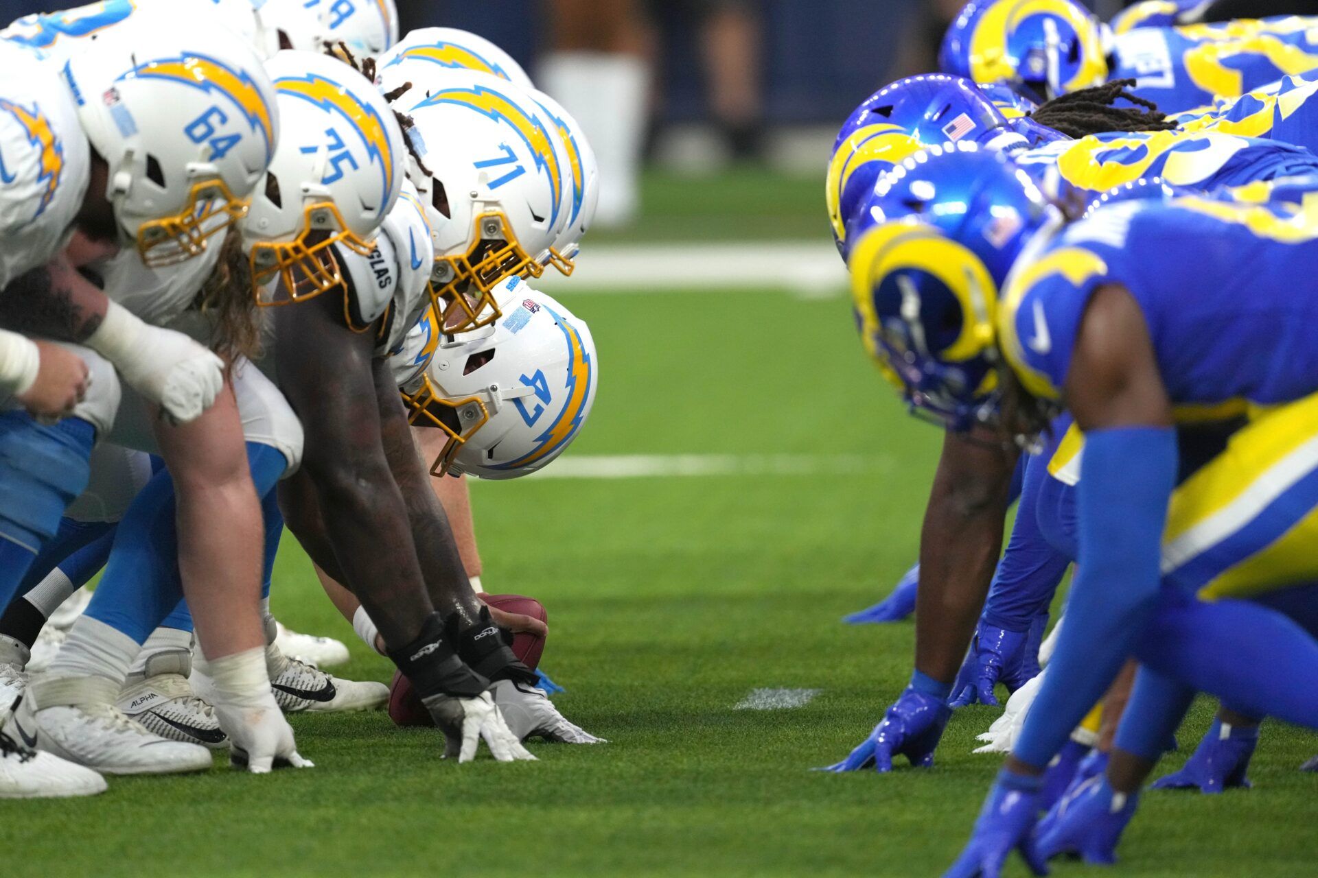 Aug 12, 2023; Inglewood, California, USA; Los Angeles Chargers and Los Angeles Rams helmets at the line of scrimmage as Chargers long snapper Josh Harris (47) snaps the ball at SoFi Stadium. Mandatory Credit: Kirby Lee-USA TODAY Sports