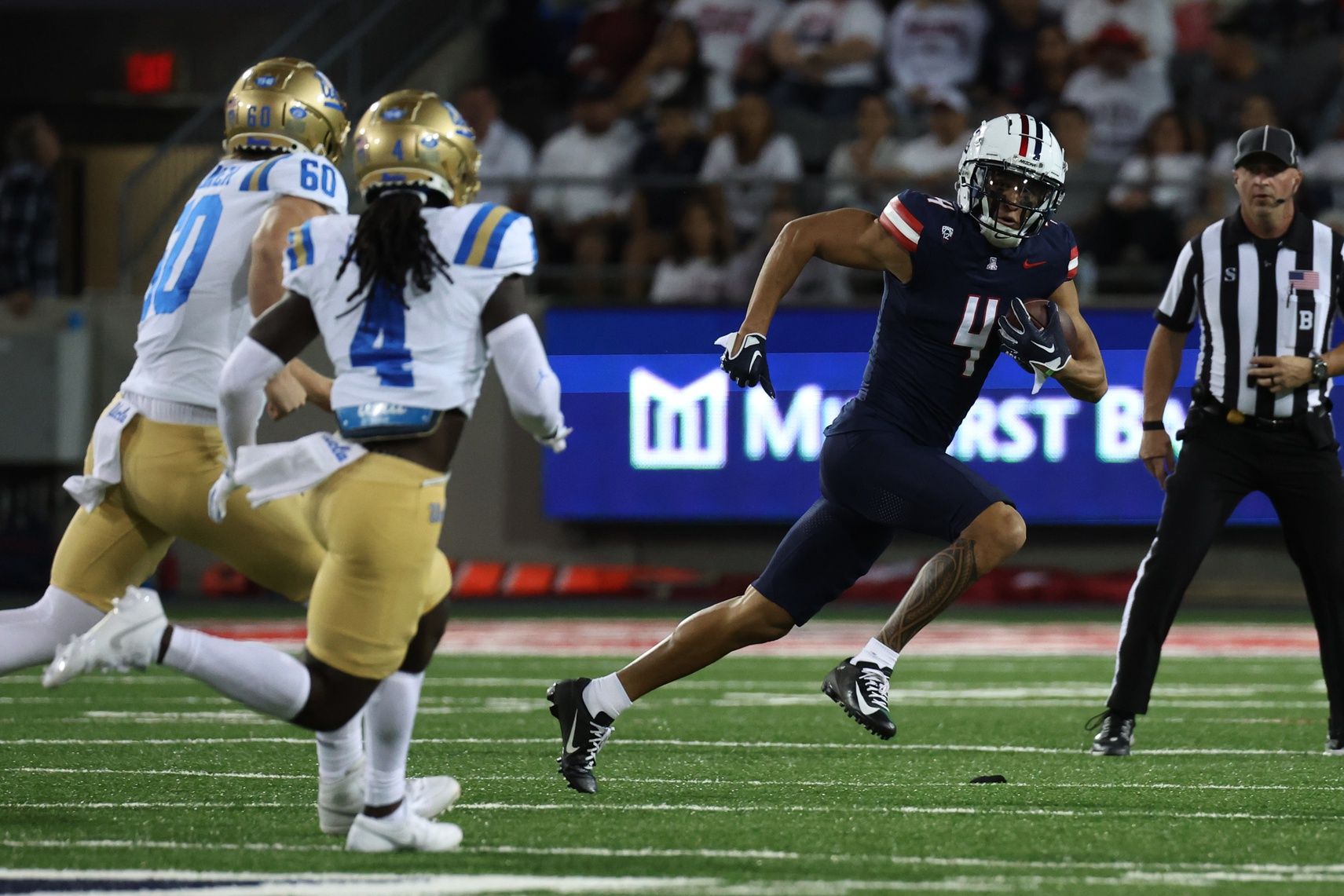 Arizona Wildcats wide receiver Tetairoa McMillan #4 returns a punt against =la4s= and UCLA Bruins long snapper Beau Gardner #60 during the first half at Arizona Stadium. Mandatory Credit: Zachary BonDurant-USA TODAY Sports