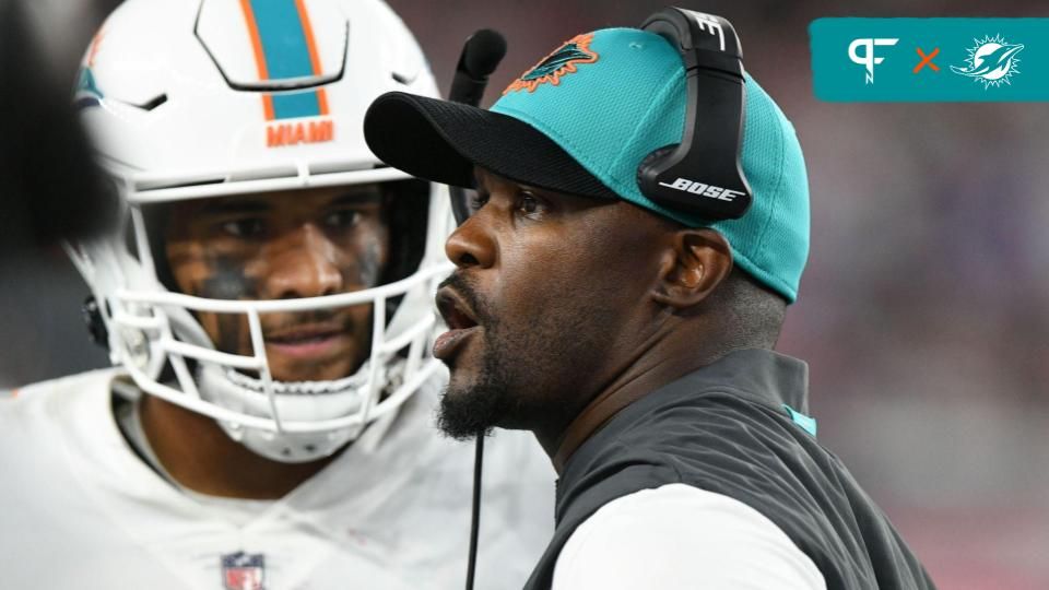 Miami Dolphins head coach Brian Flores talks with quarterback Tua Tagovailoa (1) during a timeout during the second half of a game against the New England Patriots at Gillette Stadium.