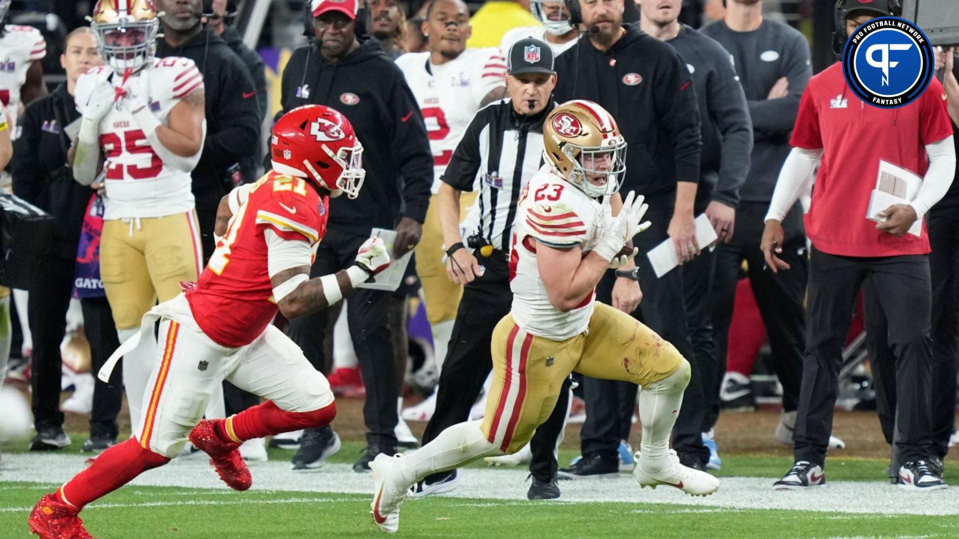 San Francisco 49ers running back Christian McCaffrey (23) runs with the ball against Kansas City Chiefs safety Mike Edwards (21) during overtime of Super Bowl LVIII at Allegiant Stadium.