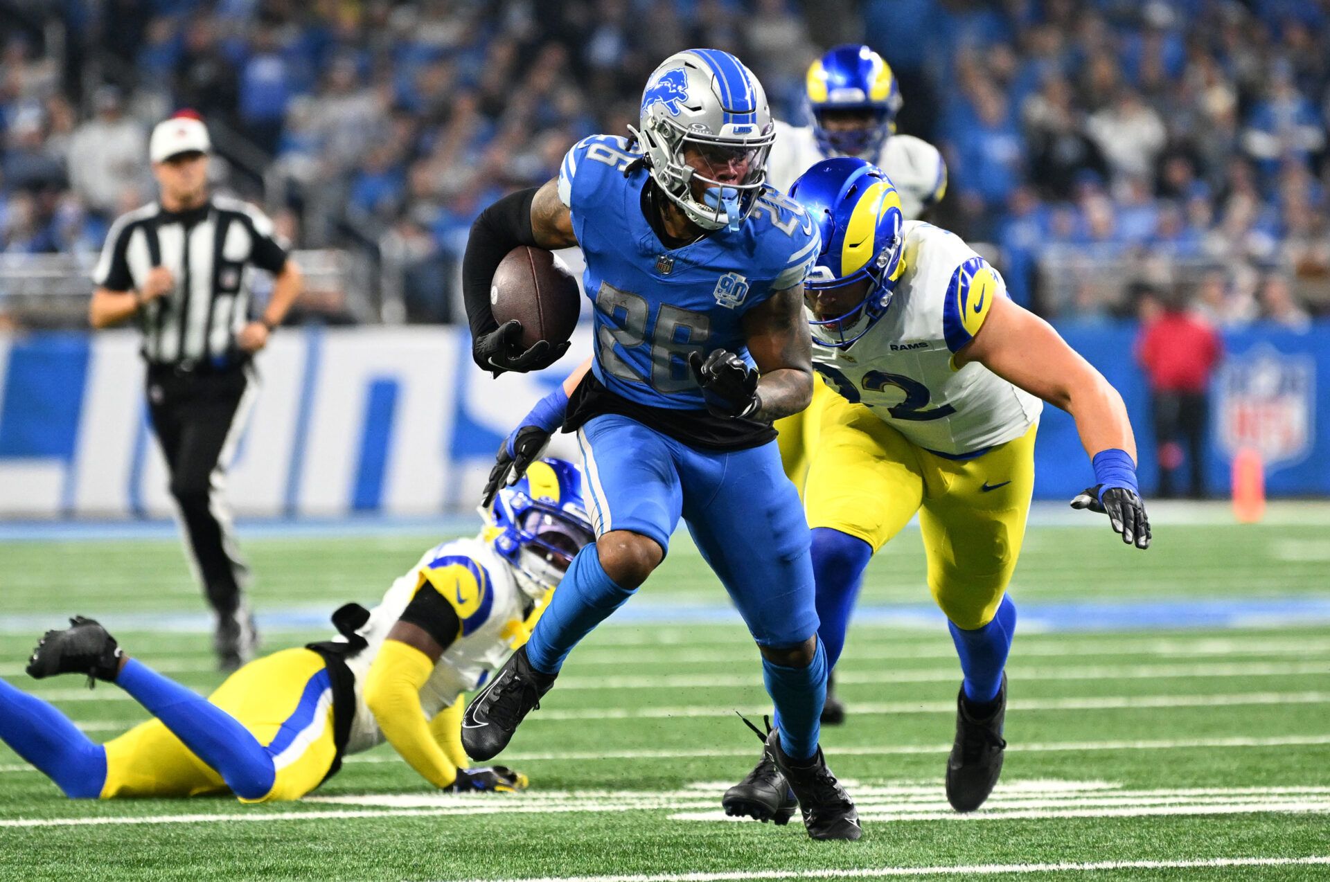 Jan 14, 2024; Detroit, Michigan, USA; Detroit Lions running back Jahmyr Gibbs (26) runs against Los Angeles Rams defensive end Jonah Williams (92) during the first half of a 2024 NFC wild card game at Ford Field. Mandatory Credit: Lon Horwedel-USA TODAY Sports