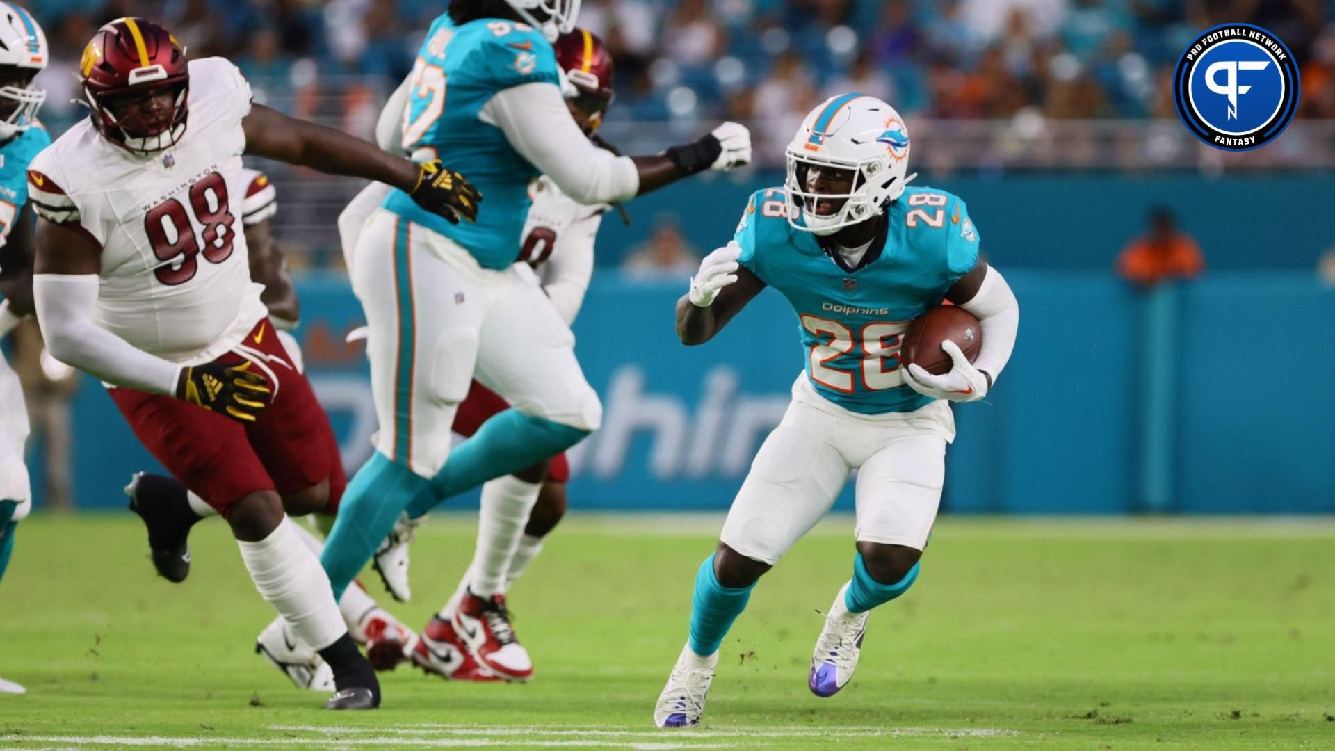 Aug 17, 2024; Miami Gardens, Florida, USA; Miami Dolphins running back De'Von Achane (28) runs with the football against the Washington Commanders during the second quarter of a preseason game at Hard Rock Stadium. Mandatory Credit: Sam Navarro-USA TODAY Sports