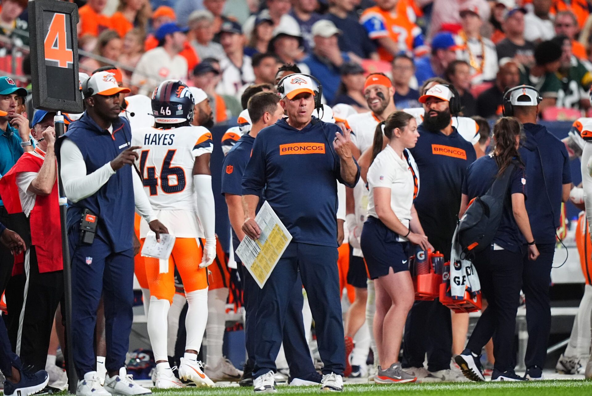 Aug 18, 2024; Denver, Colorado, USA; Denver Broncos head coach Sean Payton (center) calls in a play in the second half against the Green Bay Packers at Empower Field at Mile High. Mandatory Credit: Ron Chenoy-USA TODAY Sports