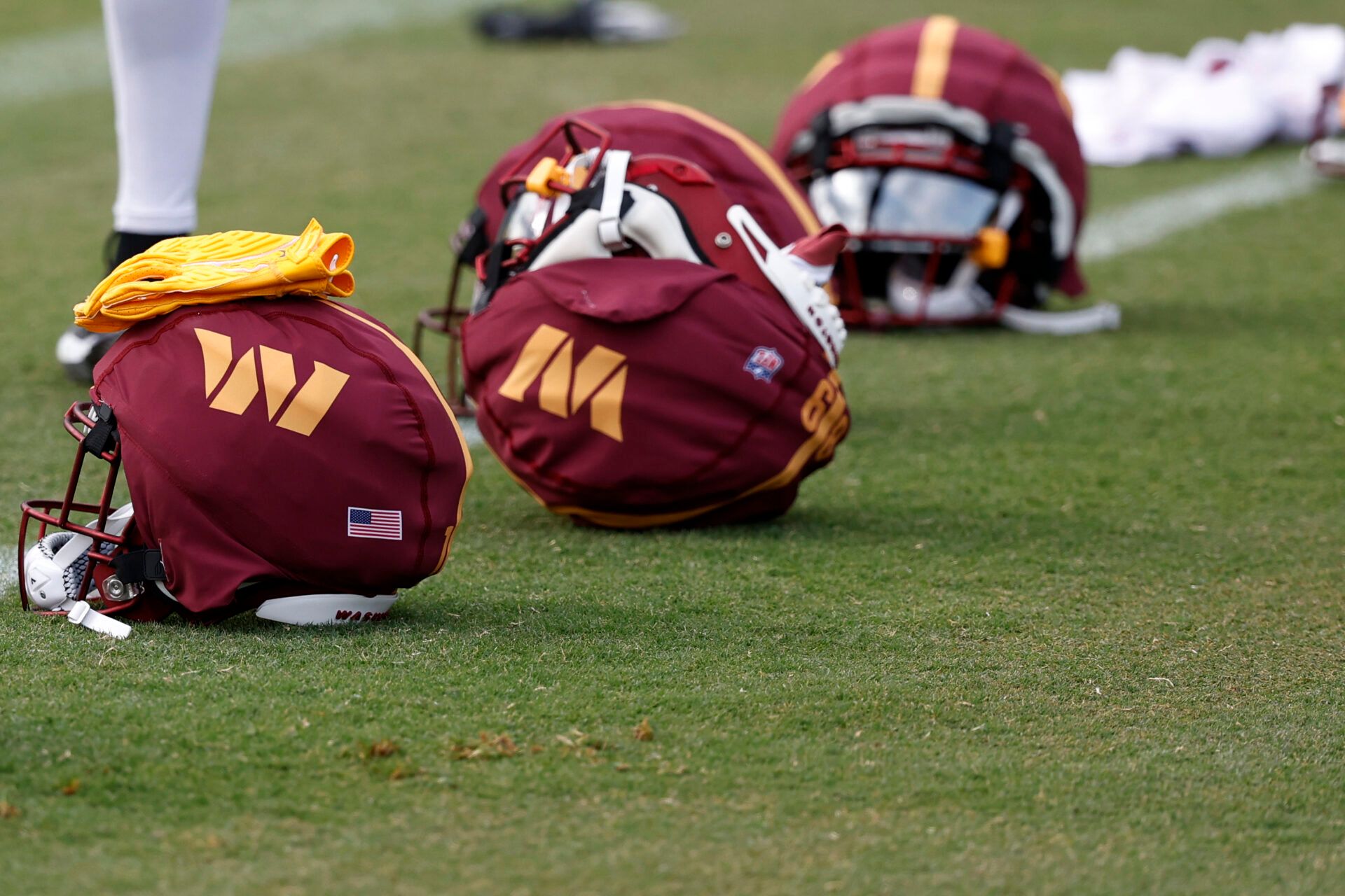 Jul 26, 2024; Ashburn, VA, USA; Washington Commanders players' helmets rest on the field on day three of training camp at Commanders Park. Mandatory Credit: Geoff Burke-USA TODAY Sports