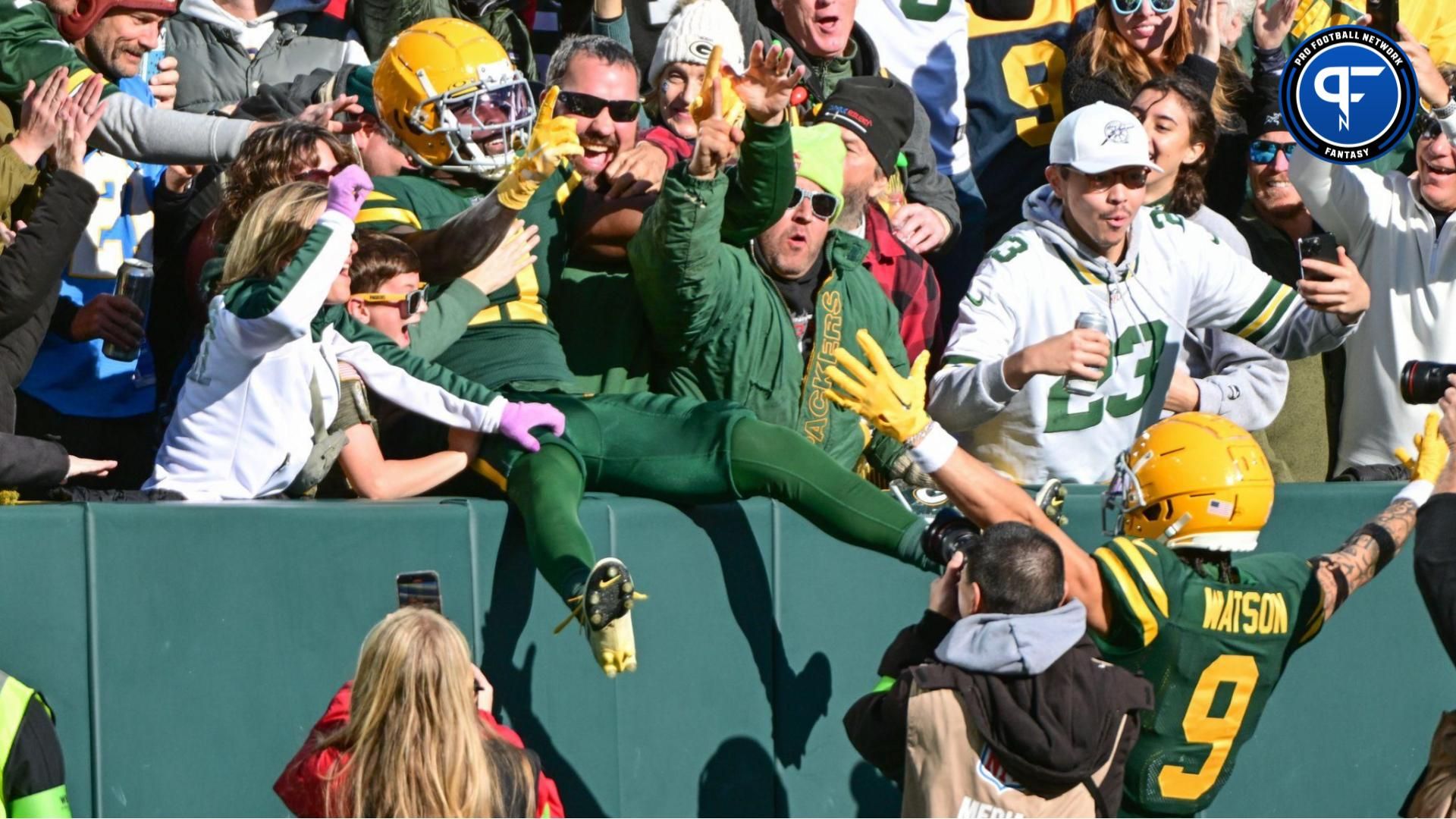 Green Bay Packers wide receiver Jayden Reed (11) celebrates with wide receiver Christian Watson (9) and fans after scoring a touchdown in the first quarter against the Los Angeles Chargers at Lambeau Field. Should you take Jayden Reed or Christian Watson in fantasy?