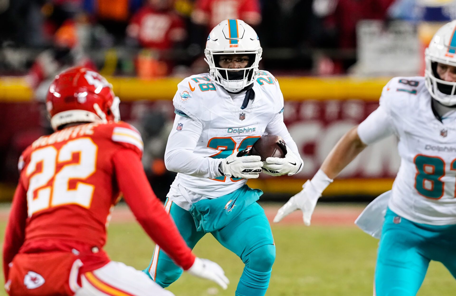 Jan 13, 2024; Kansas City, Missouri, USA; Miami Dolphins running back De'Von Achane (28) runs the ball against Kansas City Chiefs cornerback Trent McDuffie (22) during the second half of a 2024 AFC wild card game at GEHA Field at Arrowhead Stadium. Mandatory Credit: Jay Biggerstaff-USA TODAY Sports