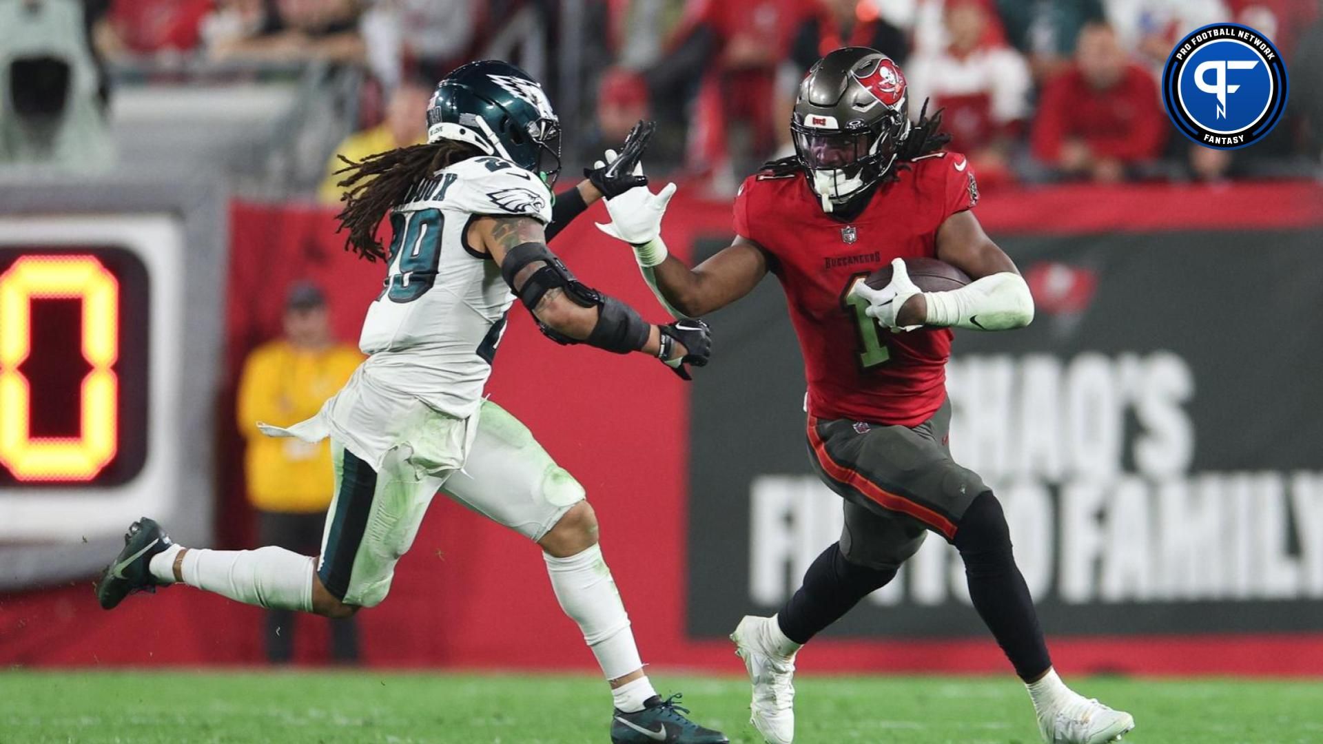 Tampa Bay Buccaneers running back Rachaad White (1) fends off Philadelphia Eagles cornerback Avonte Maddox (29) during the second half of a 2024 NFC wild card game at Raymond James Stadium.