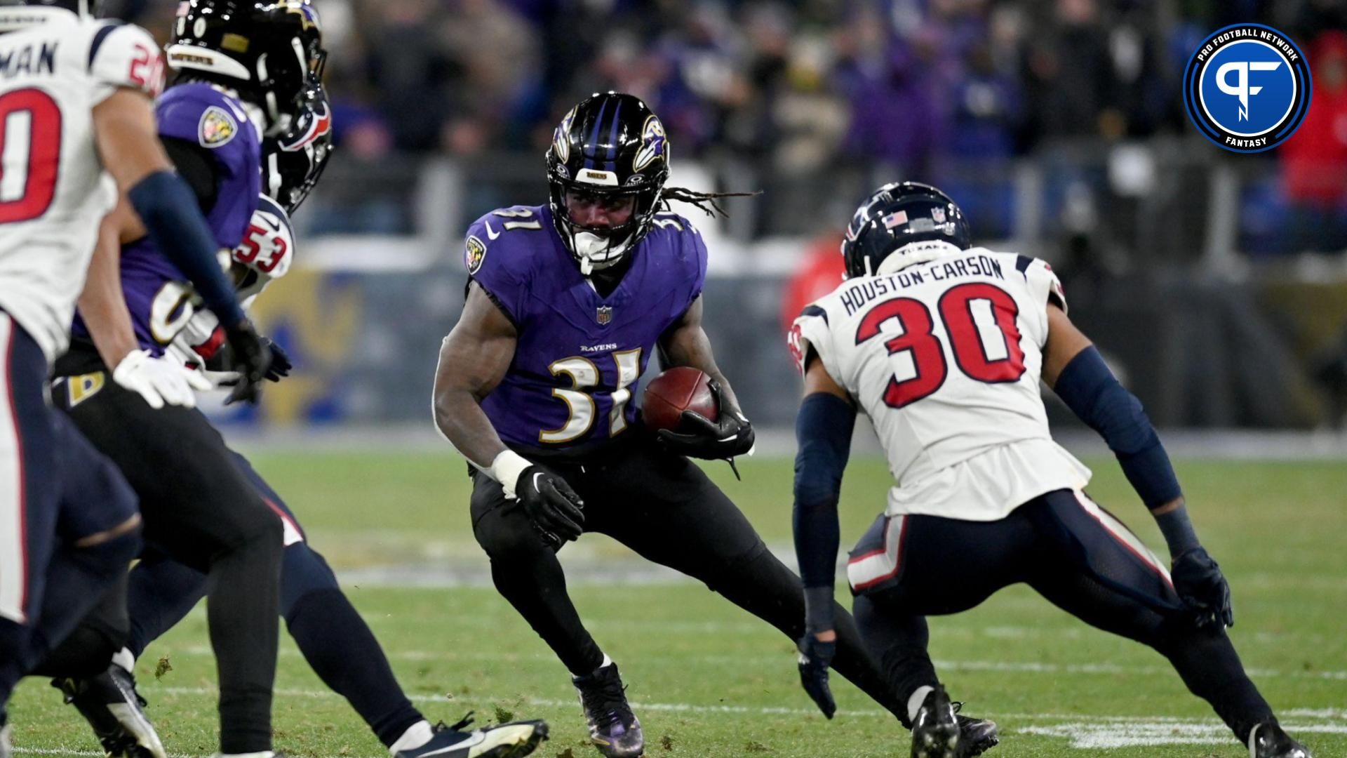 Jan 20, 2024; Baltimore, MD, USA; Baltimore Ravens running back Dalvin Cook (31) runs the ball against Houston Texans linebacker Blake Cashman (53) and safety DeAndre Houston-Carson (30) during the fourth quarter of a 2024 AFC divisional round game at M&T Bank Stadium. Mandatory Credit: Tommy Gilligan-USA TODAY Sports