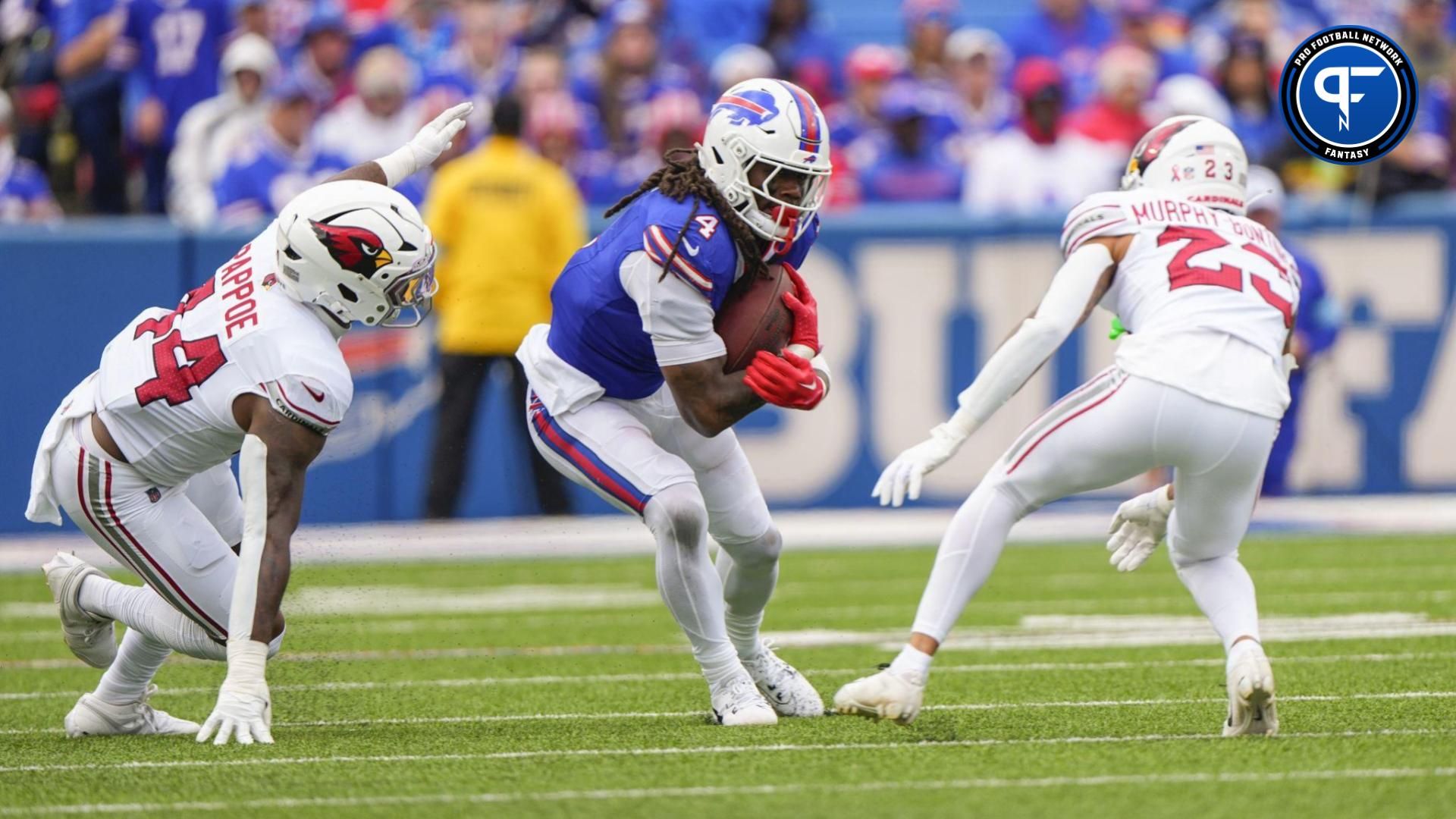 Buffalo Bills running back James Cook (4) runs with the ball between Arizona Cardinals linebacker Owen Pappoe (44) and Arizona Cardinals cornerback Sean Murphy-Bunting (23) during the second half at Highmark Stadium. Where does Cook fall in our Thursday Night Football start/sit for Week 2? Mandatory Credit: Gregory Fisher-Imagn Images